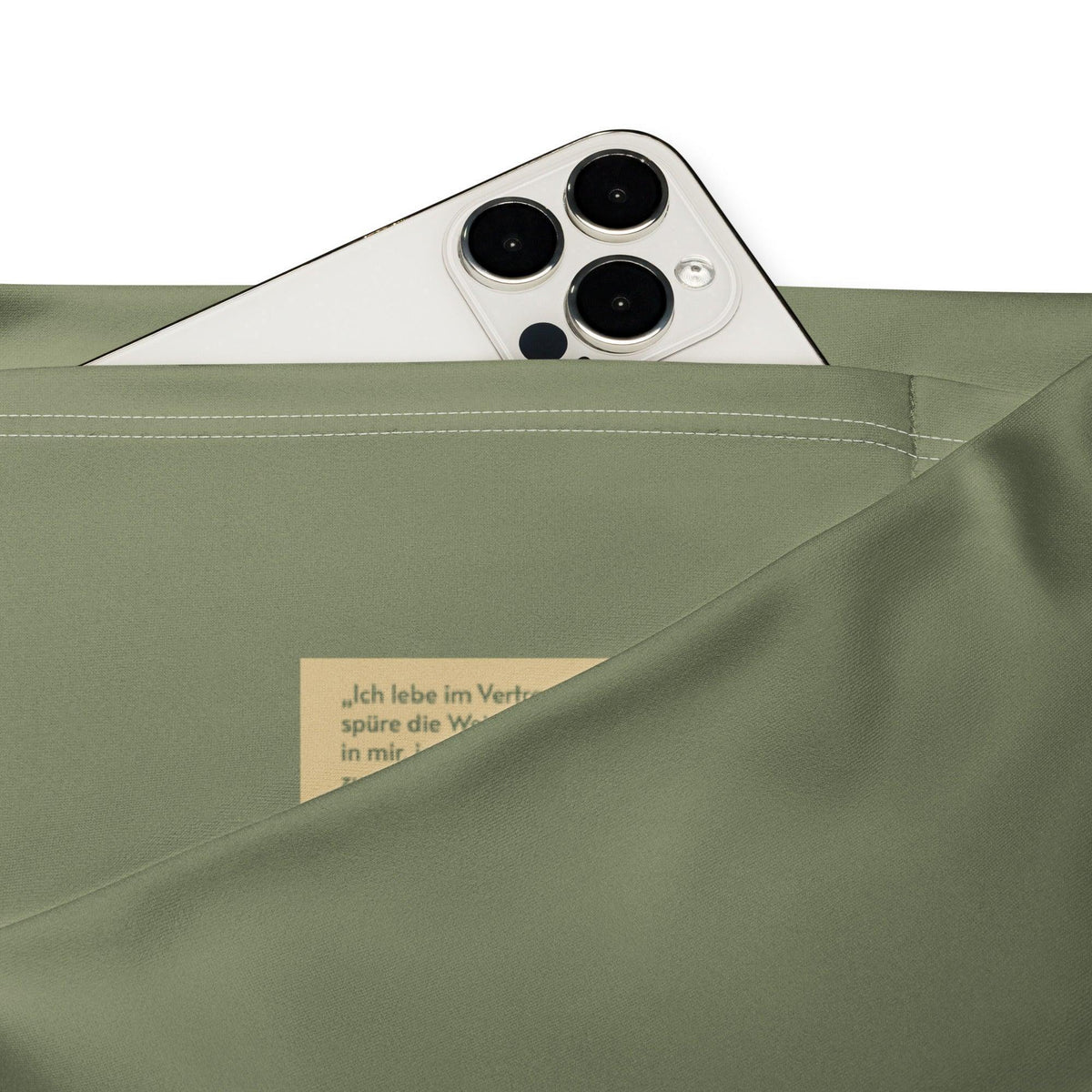 Detailansicht einer olivgrünen CREWILD Leggings mit Handytasche und Zitat-Label.