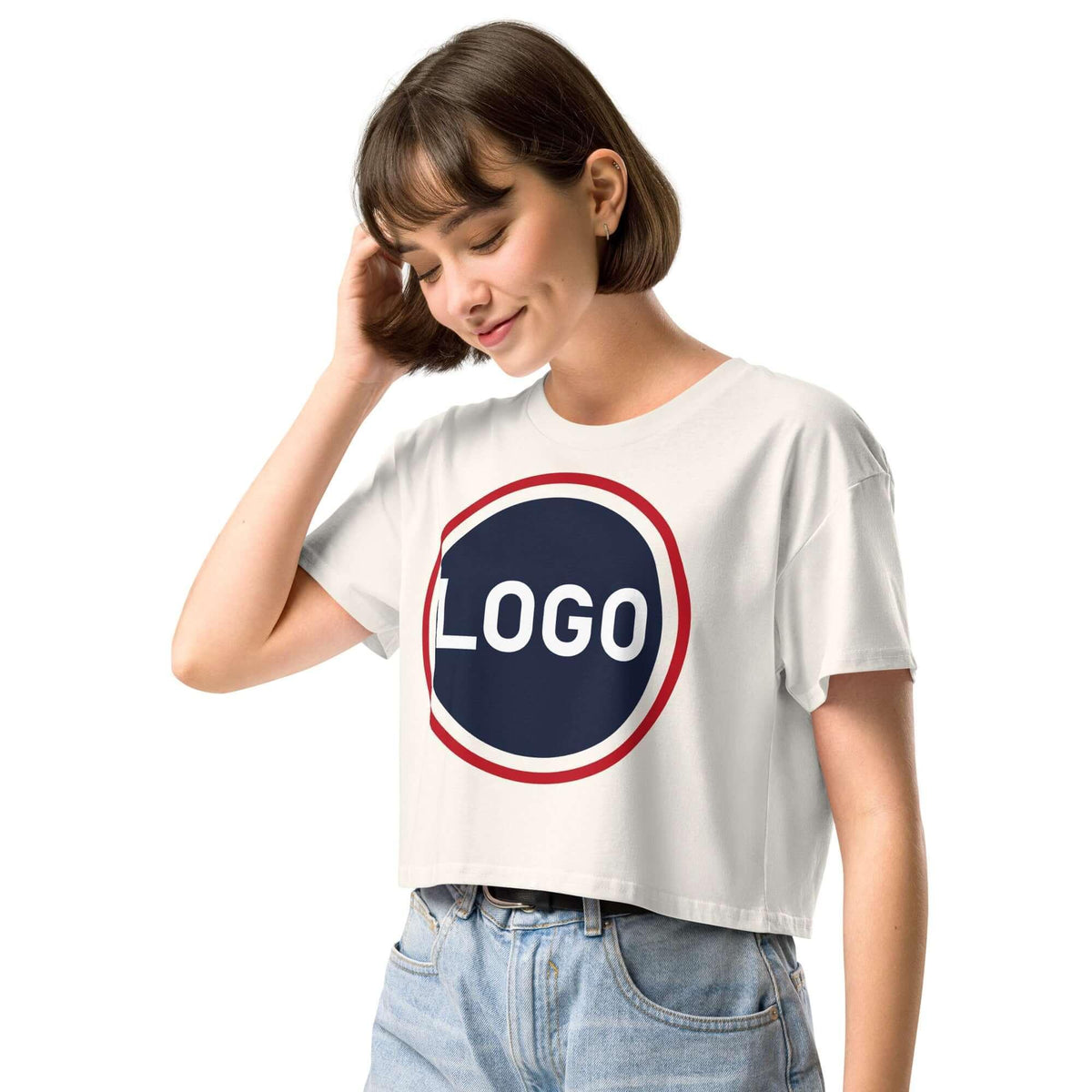 Frau in weißem, kurz geschnittenem T-Shirt mit rundem Logo-Print auf weißem Hintergrund