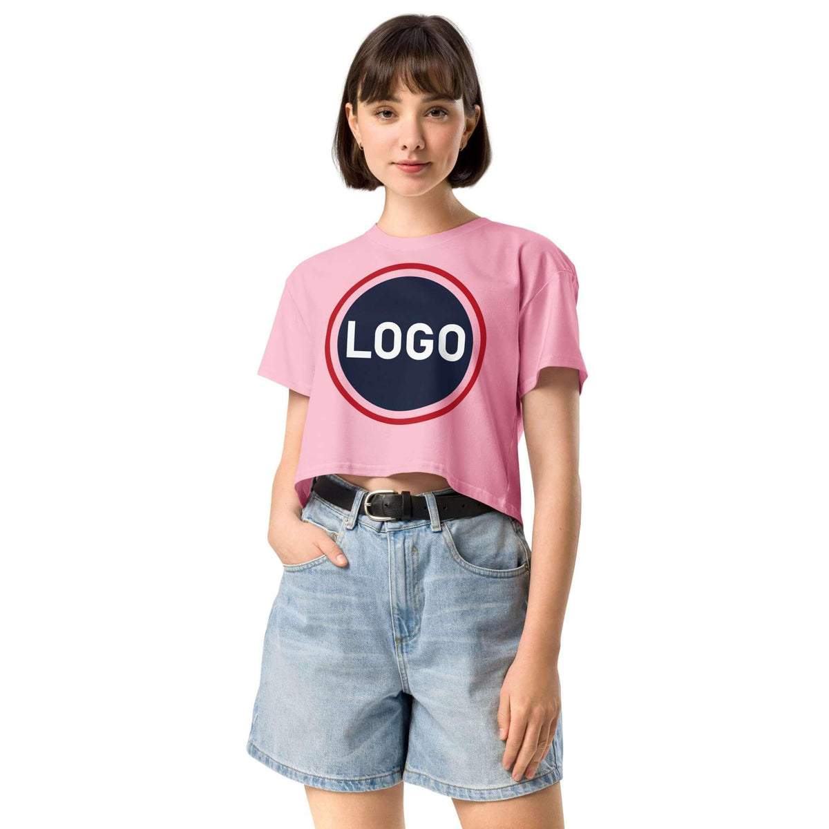 Frau in rosa Crop-T-Shirt mit rundem Logo-Print und hellblauen Jeans-Shorts