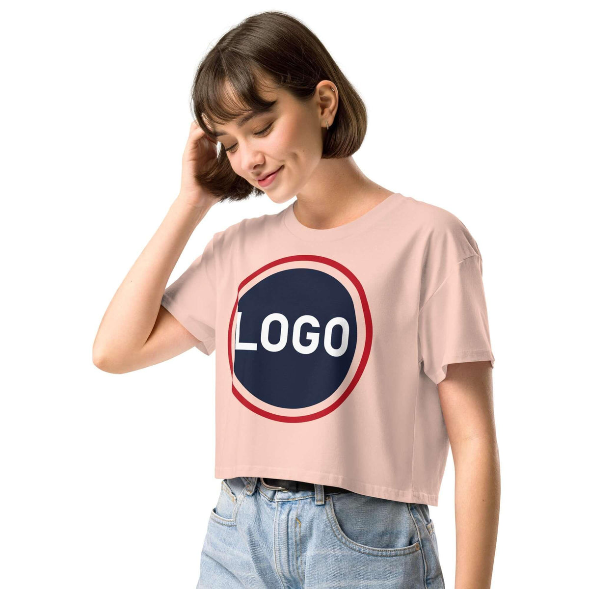 Frau trägt ein hellrosa, kurz geschnittenes T-Shirt mit einem runden Logo-Print.