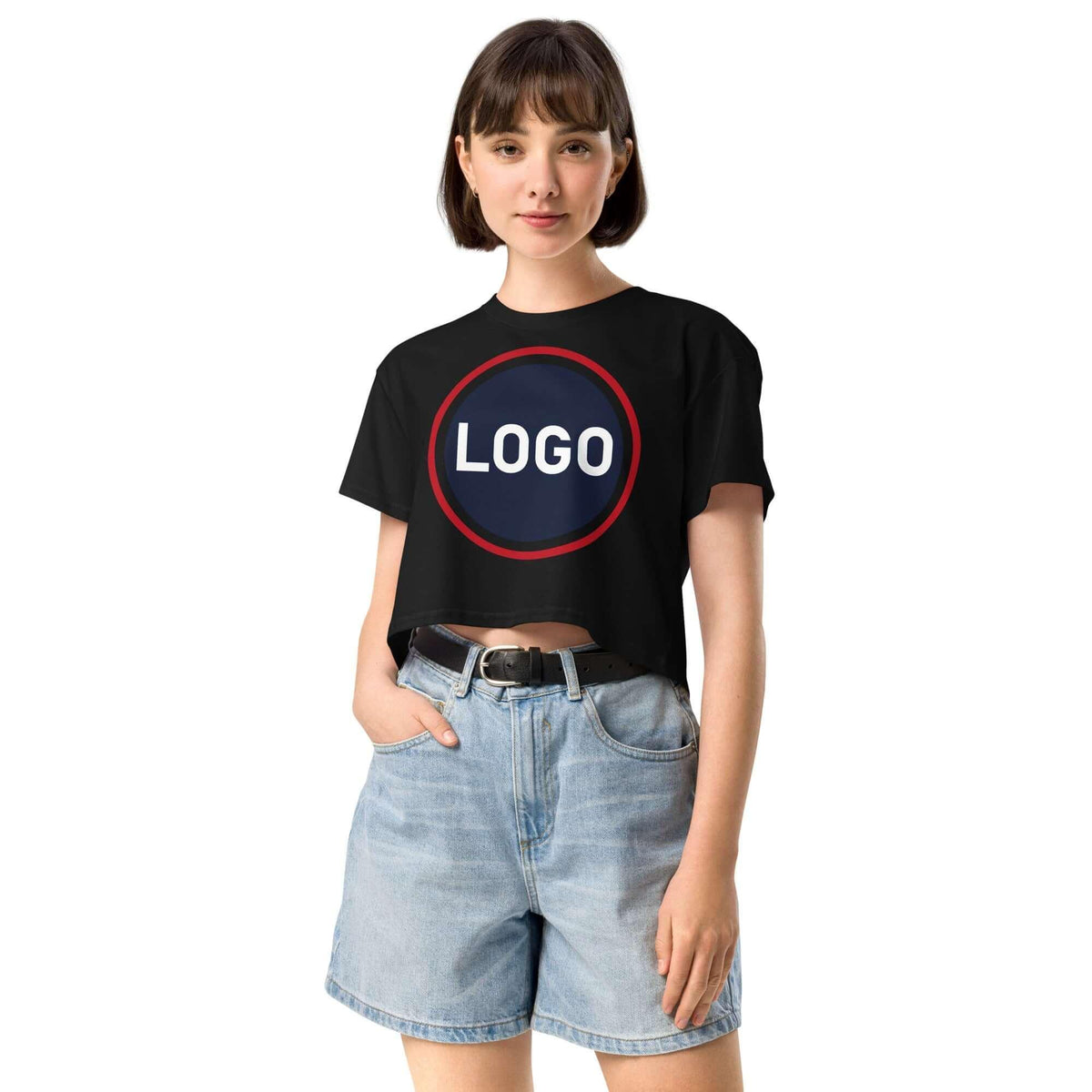 Frau in schwarzem Crop-T-Shirt mit rundem Logo-Print und hellblauen Jeans-Shorts