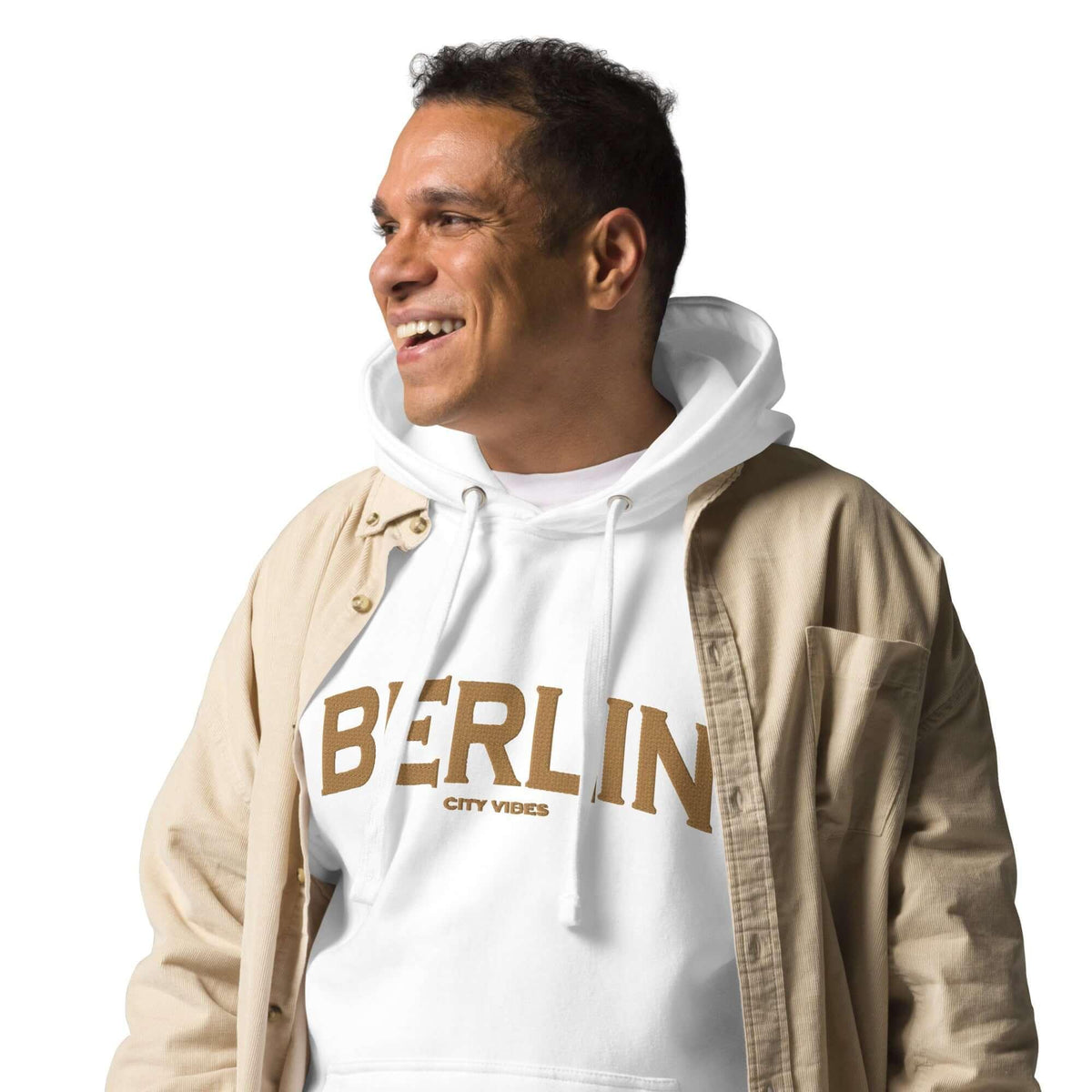 Mann trägt einen weißen CREWILD Hoodie mit goldenem BERLIN Schriftzug und beige Jacke.