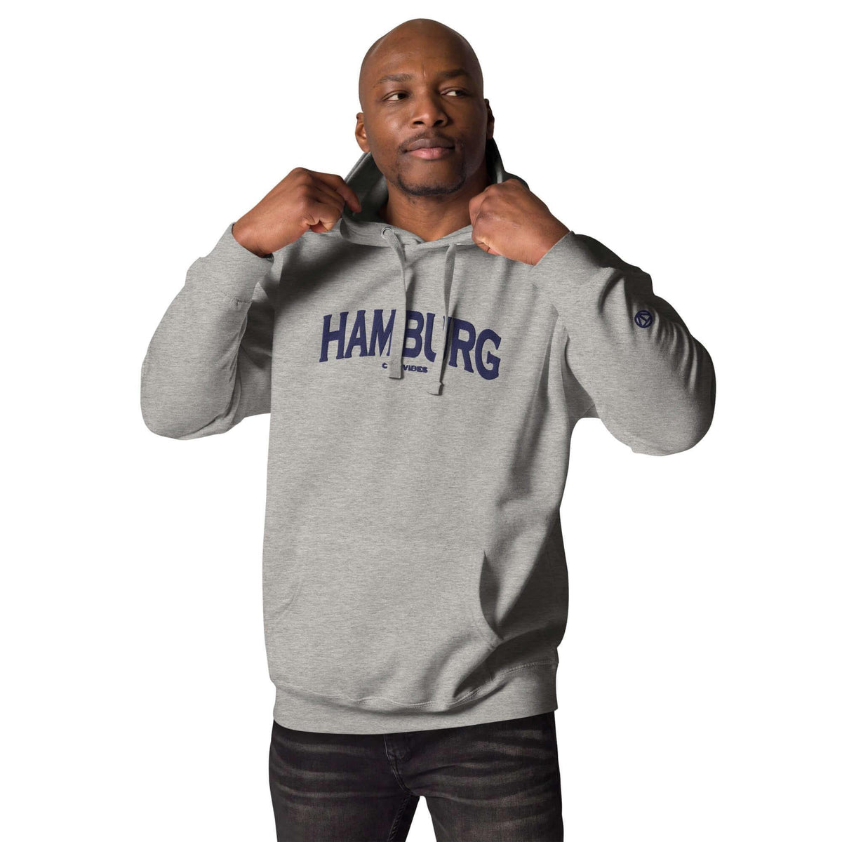 Mann trägt grauen CREWILD Hoodie mit blauem Hamburg-Schriftzug