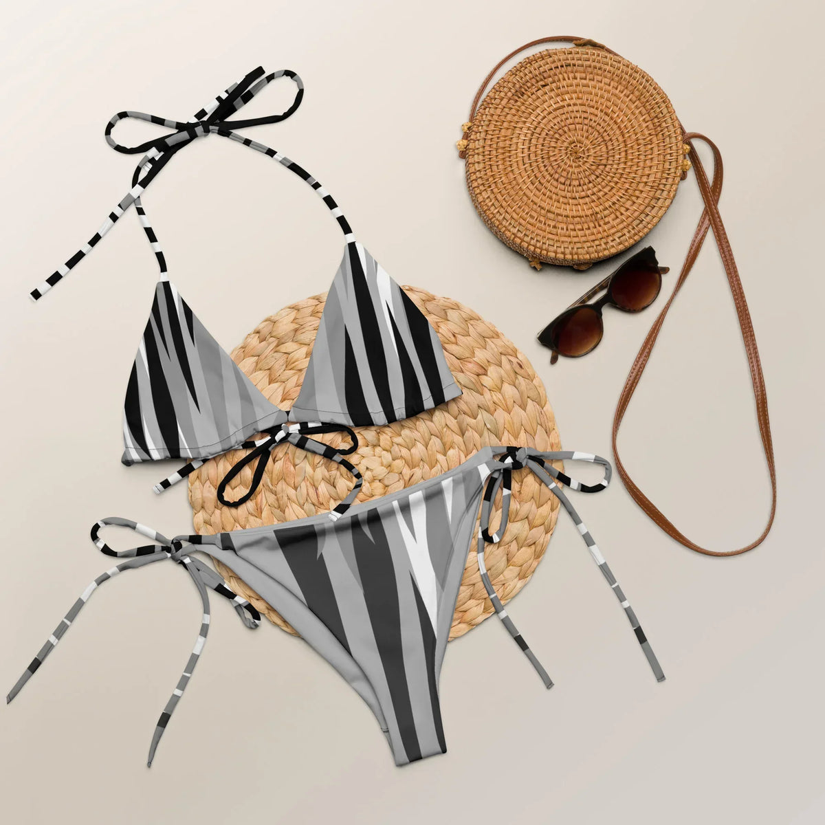 Grauer CREWILD Schnür-Bikini mit Tiger-Print, kombiniert mit Strohtasche und Sonnenbrille.