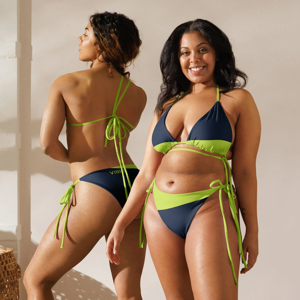 Zwei Frauen im CREWILD Schnür-Bikini WAVES in Dunkelblau und Neongrün.