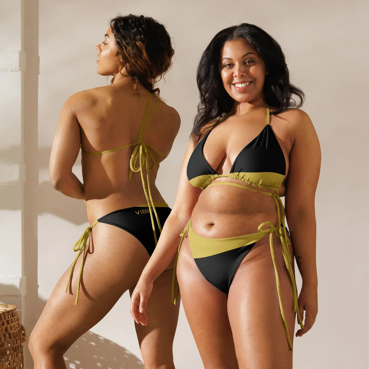 Zwei Frauen im CREWILD Schnür-Bikini WAVES in Schwarz und Gold.
