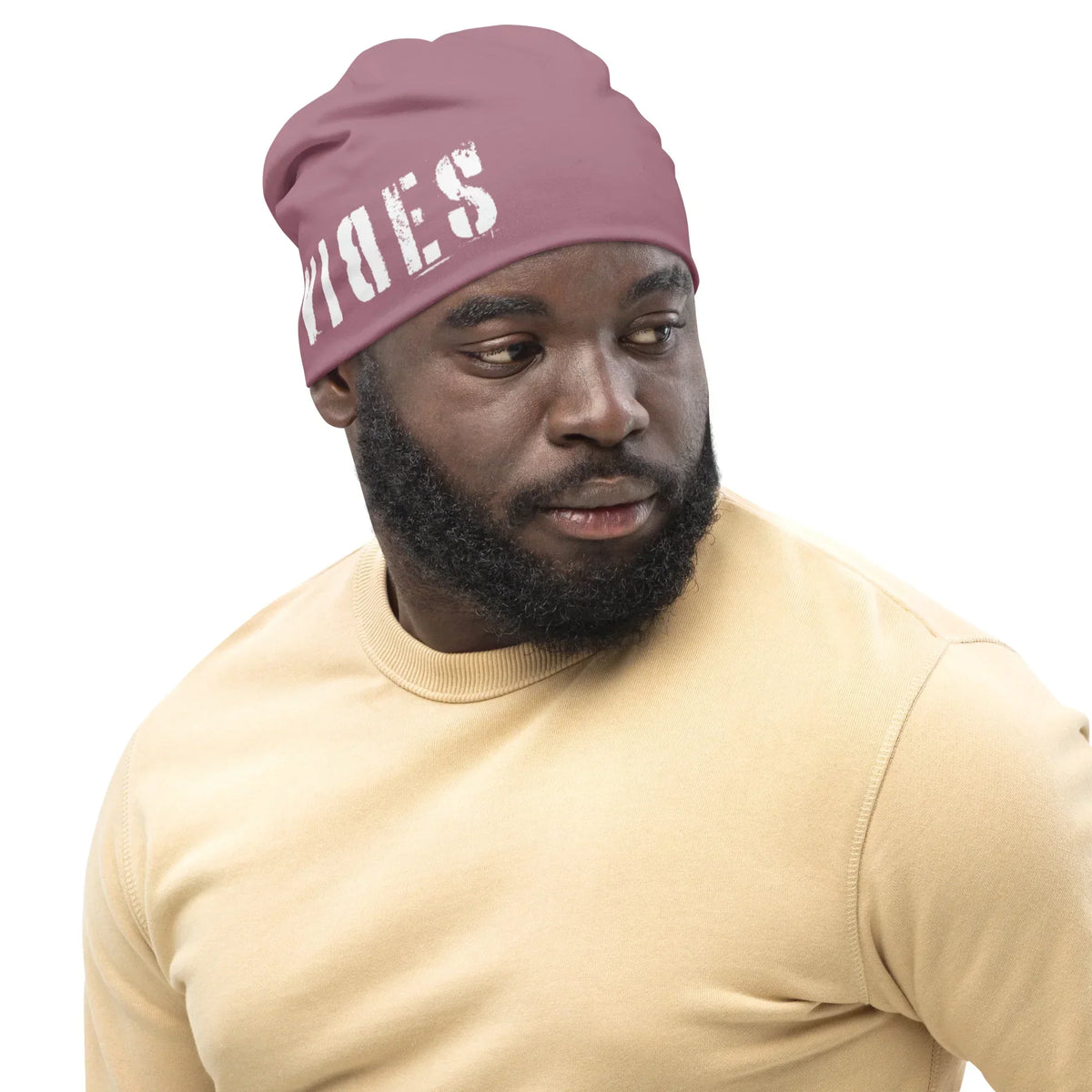 Mann mit lila CREWILD Beanie mit weißem VIBES-Schriftzug und beigem Sweatshirt