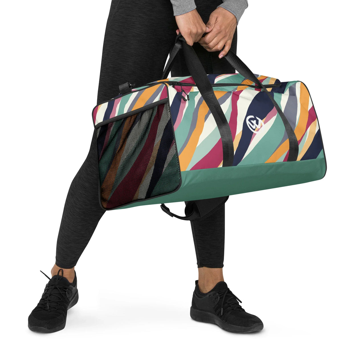 Person trägt eine bunte Sporttasche mit Wellenmuster und Netzfach.