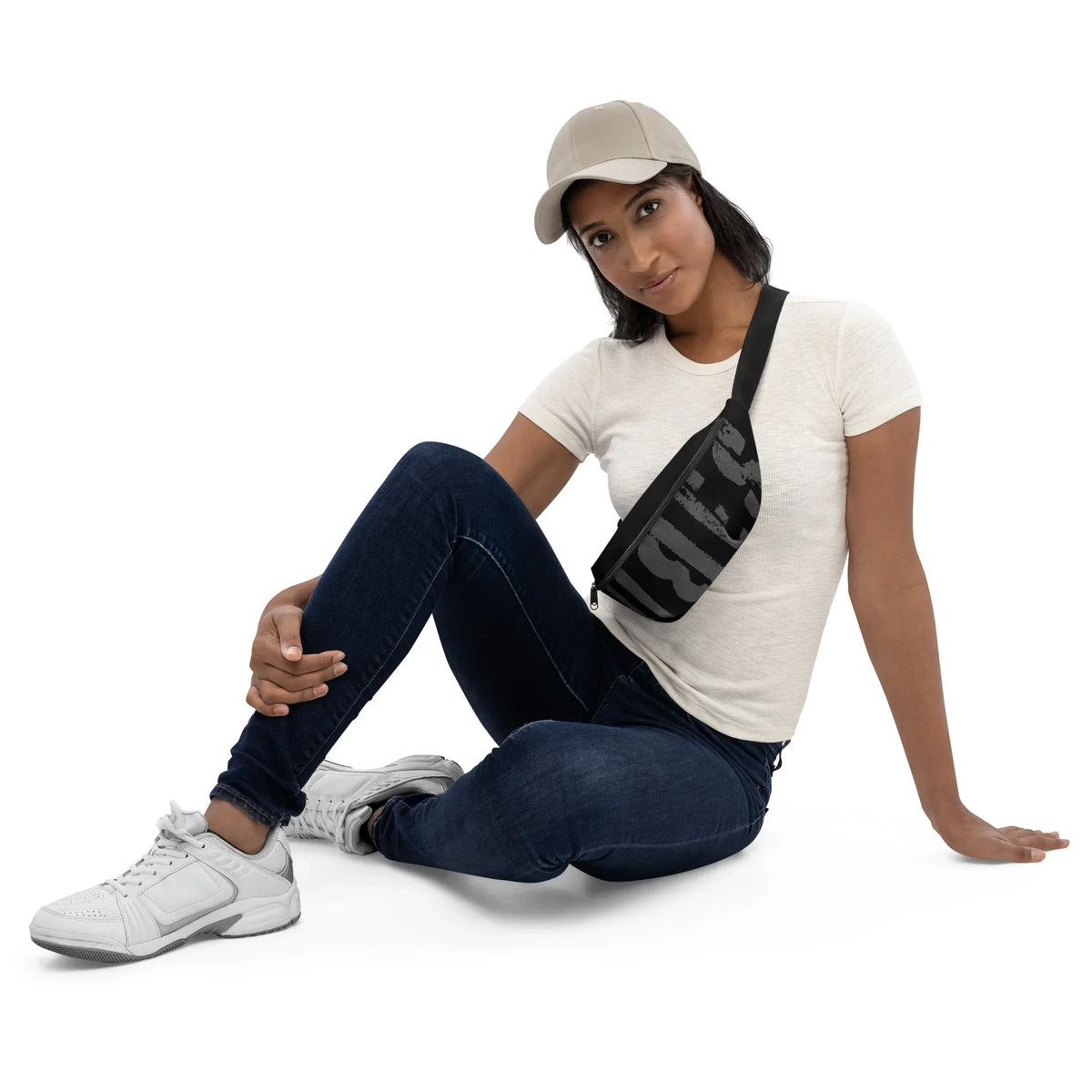 Frau mit weißem T-Shirt, dunkelblauen Jeans, weißem Sneaker und schwarzer Gürteltasche