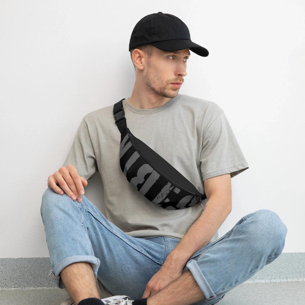 Mann mit schwarzer Basecap, grauem T-Shirt und einer schwarz-grau gemusterten Gürteltasche