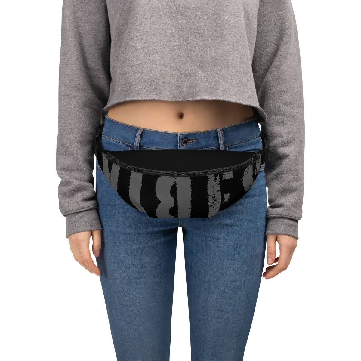 Schwarze Gürteltasche mit grauem Schriftzug an einer Person mit Jeans und grauem Sweatshirt