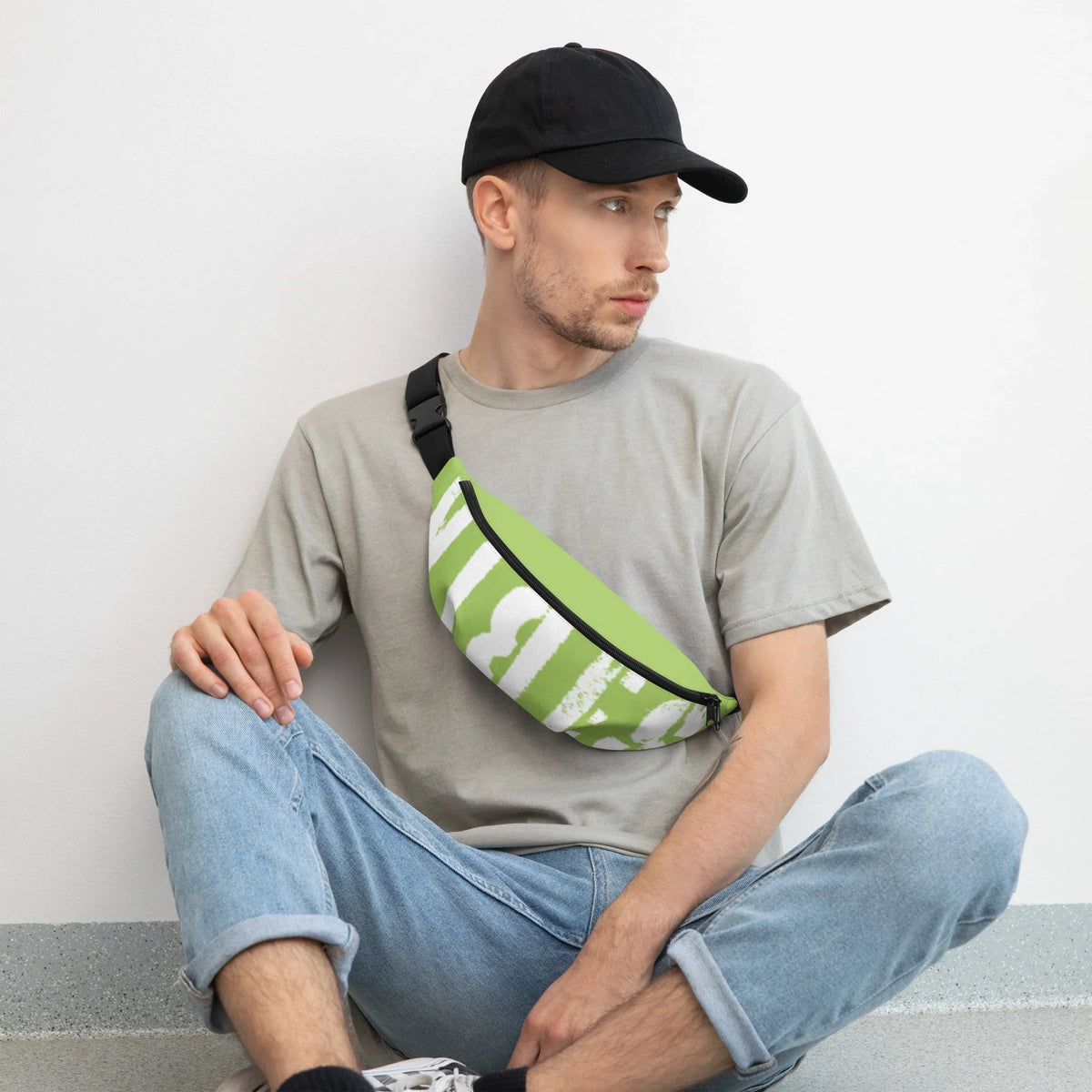 Mann mit schwarzer Kappe, grauem T-Shirt und einer grün-weißen Gürteltasche.