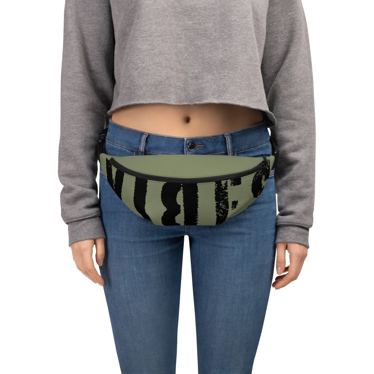 Person in Jeans und grauem Crop-Top mit olivgrüner Bauchtasche mit schwarzem Grafikprint