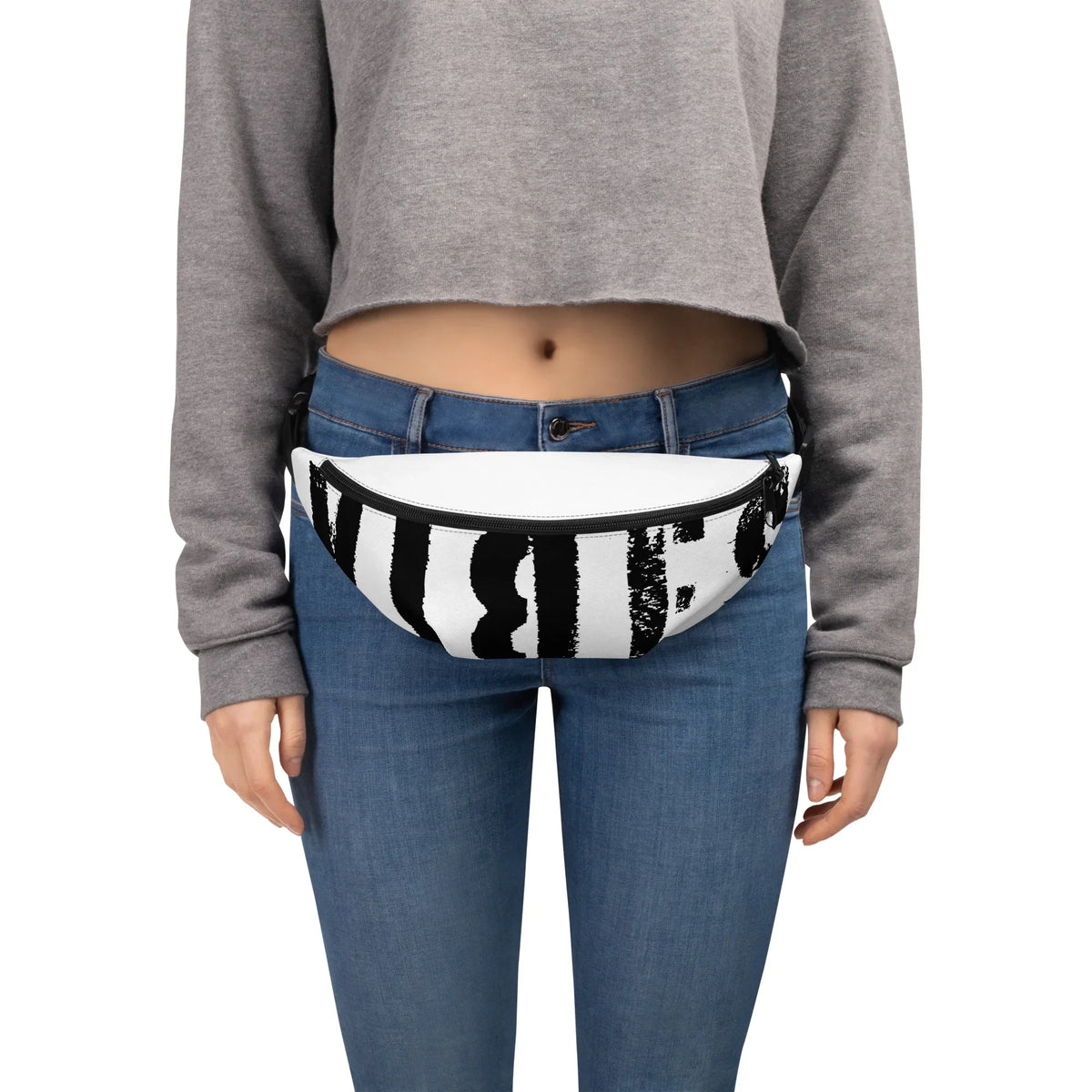 Weiße Bauchtasche mit schwarzem Grafikprint an einer Person mit Jeans und grauem Crop-Sweatshirt
