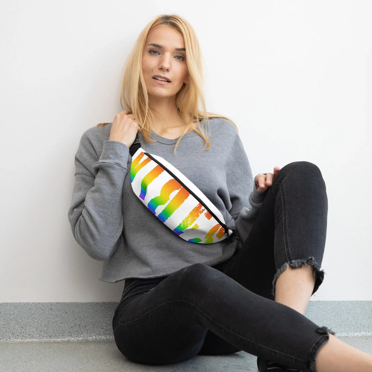 Frau mit grauem Sweatshirt und einer bunten Regenbogen-Bauchtasche