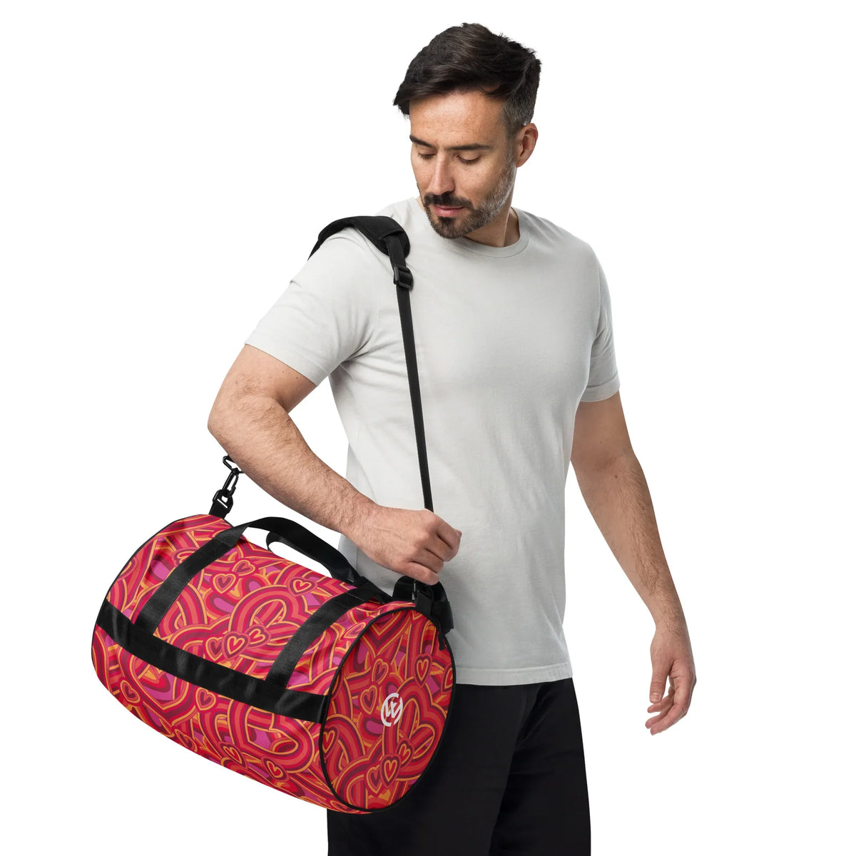 Mann mit CREWILD Sporttasche im roten Herz-Design über der Schulter