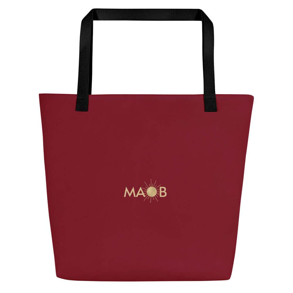 Weinrote CREWILD Tragetasche mit goldfarbenem MAOB Logo und Sonnen-Symbol