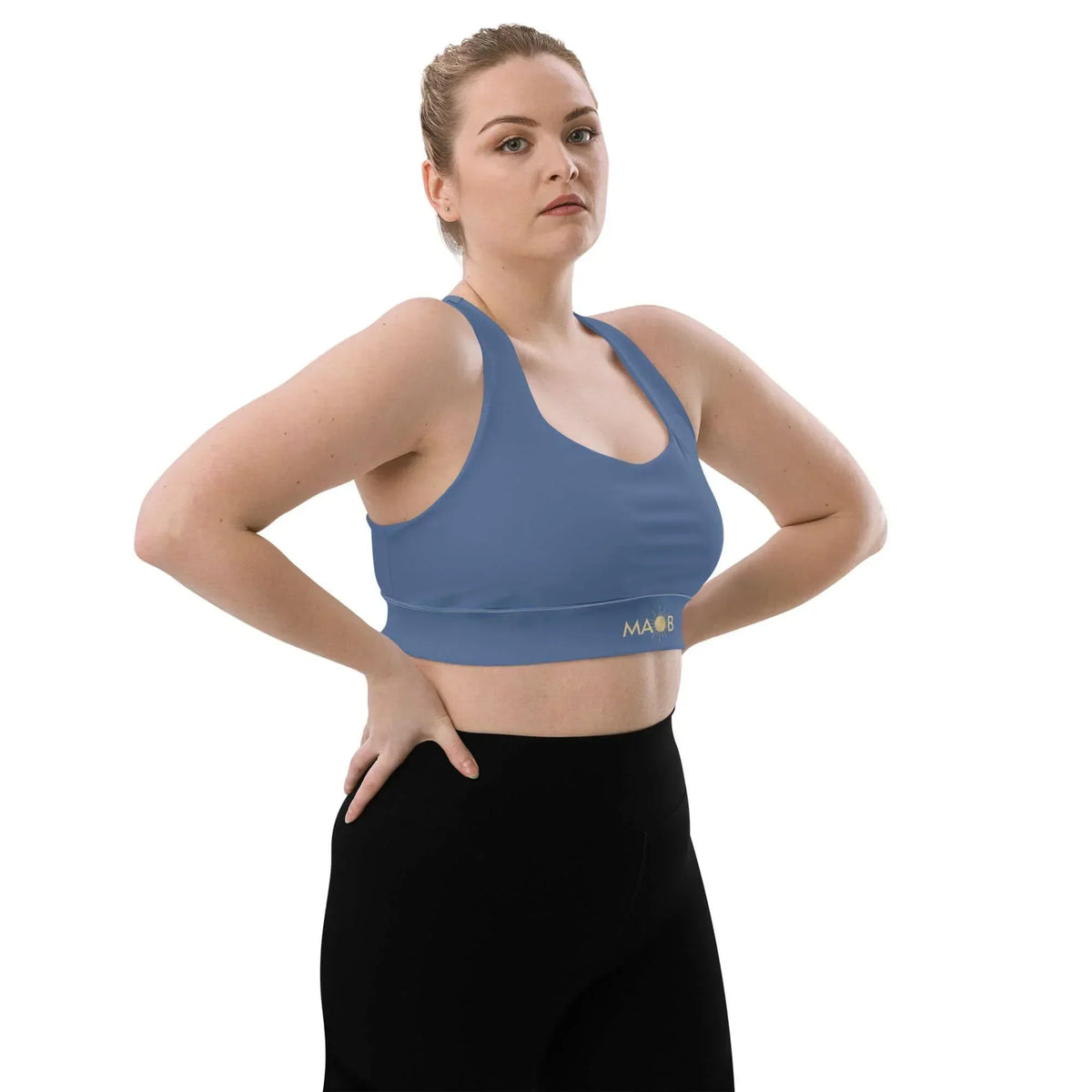 Frau trägt einen blauen CREWILD MAOB Sport-BH in der Farbe Wasser und schwarze Leggings.