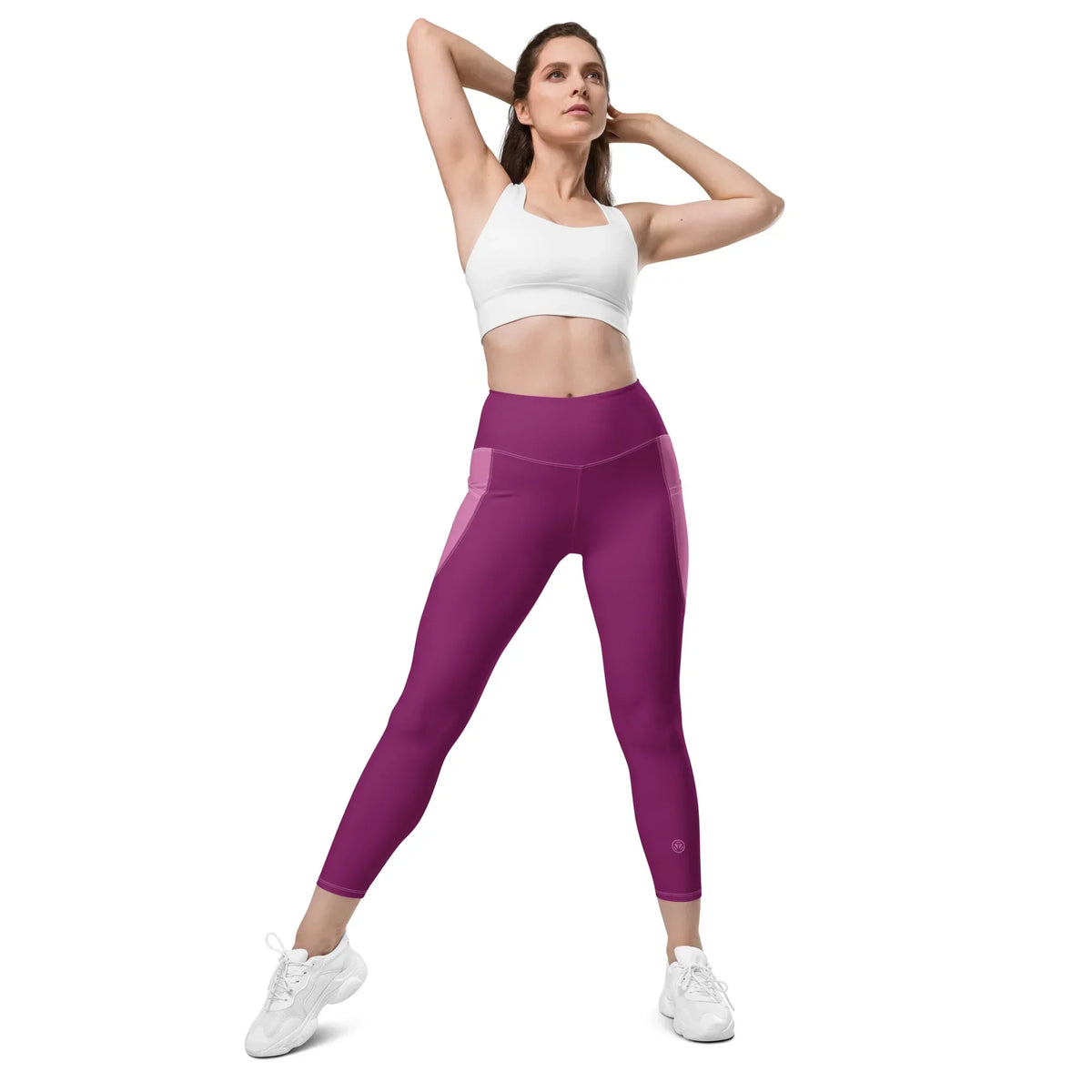 Frau in weißen Sneakern und pinken CREWILD Leggings mit Taschen und weißem Sport-Top