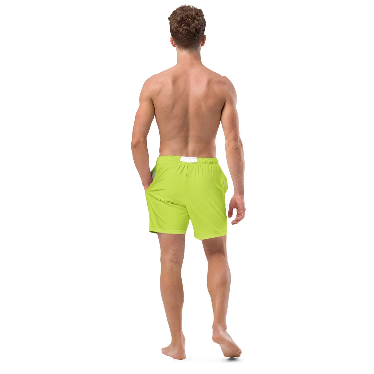 Rückansicht eines Mannes in neongrünen CREWILD Badeshorts vor weißem Hintergrund