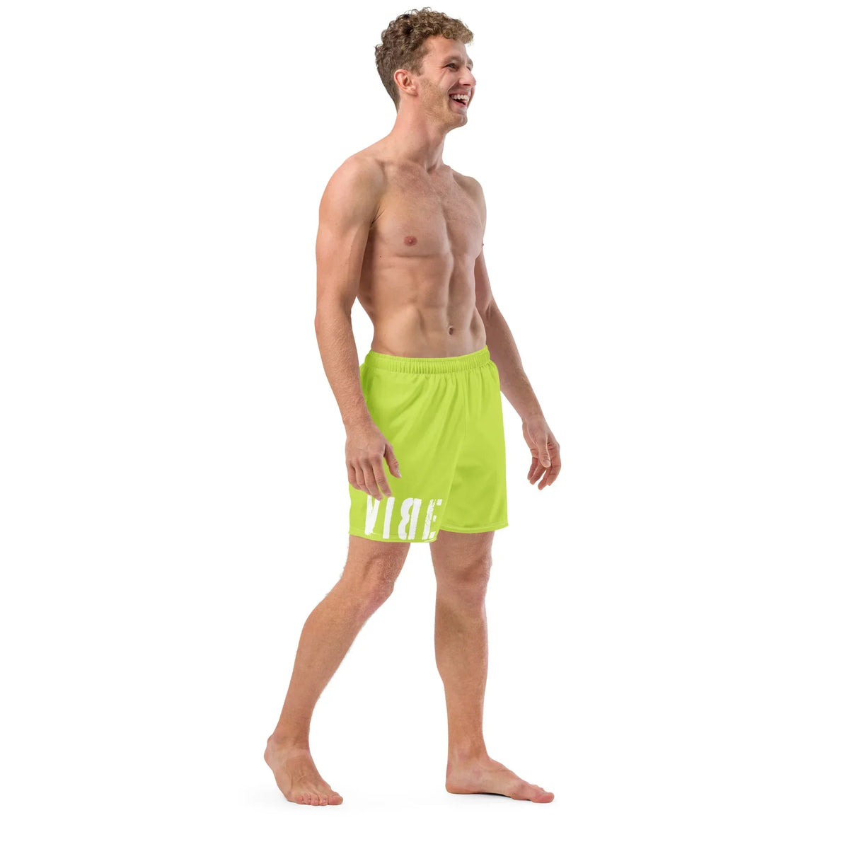 Mann in neongrünen CREWILD Badeshorts mit weißem Schriftzug vor weißem Hintergrund