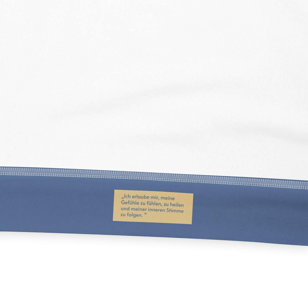 Nahaufnahme eines blauen CREWILD Hoodie-Details mit Affirmationstext in Gelb