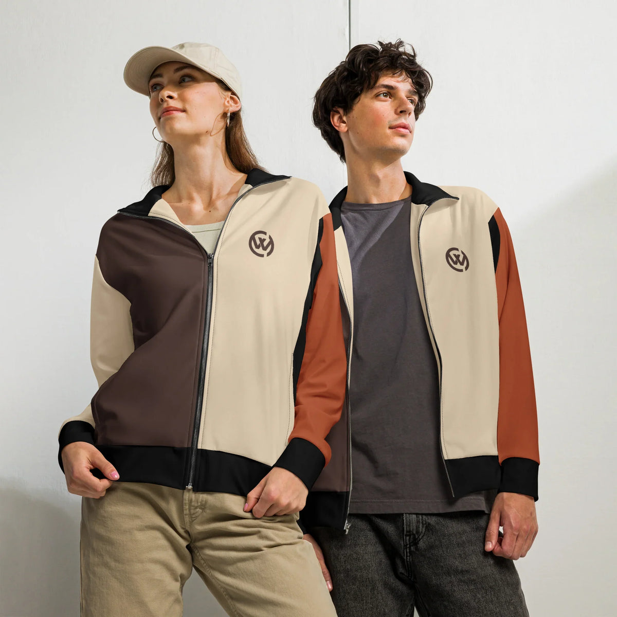Zwei Personen tragen die Unisex CREWILD Jacke in Braun und Creme mit Logo.