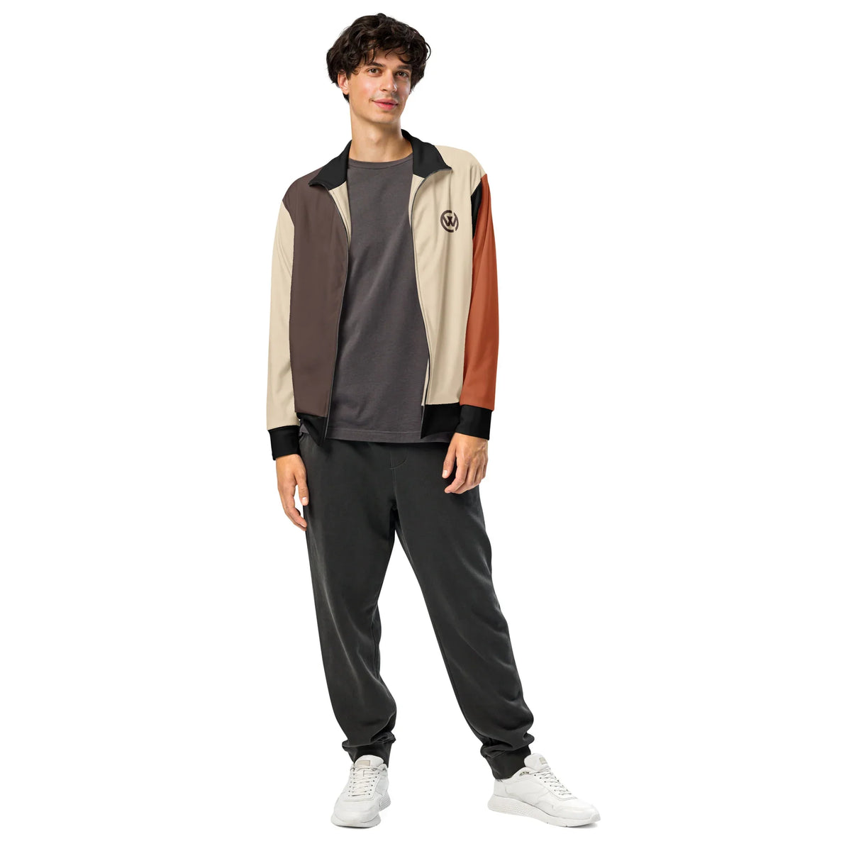 Mann in einer CREWILD Jacke in Braun und Creme mit grauen Jogginghosen und weißen Sneakern