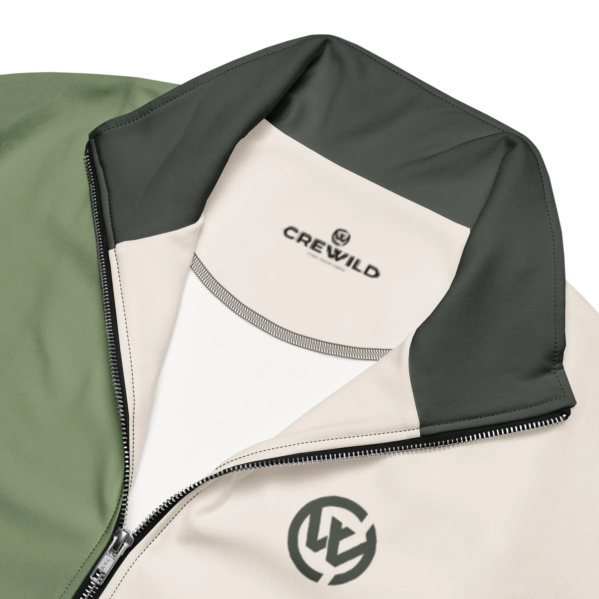 Nahaufnahme der CREWILD Jacke in Creme und Grün mit Logo-Stickerei und Reißverschluss