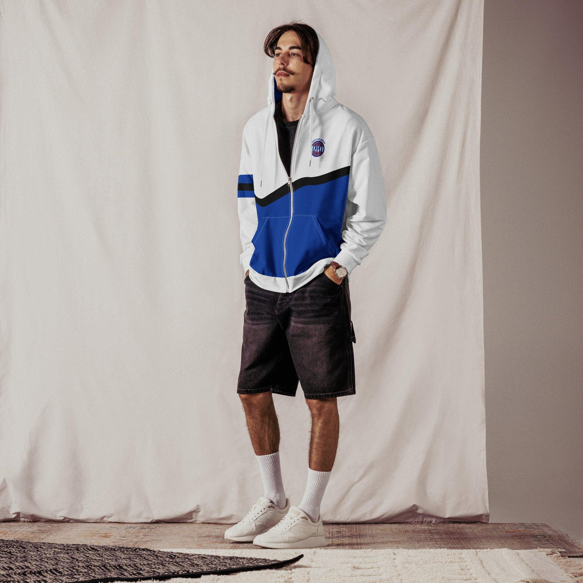 Mann trägt einen weiß-blauen CREWILD ICA Zip Hoodie mit Shorts und weißen Sneakern.