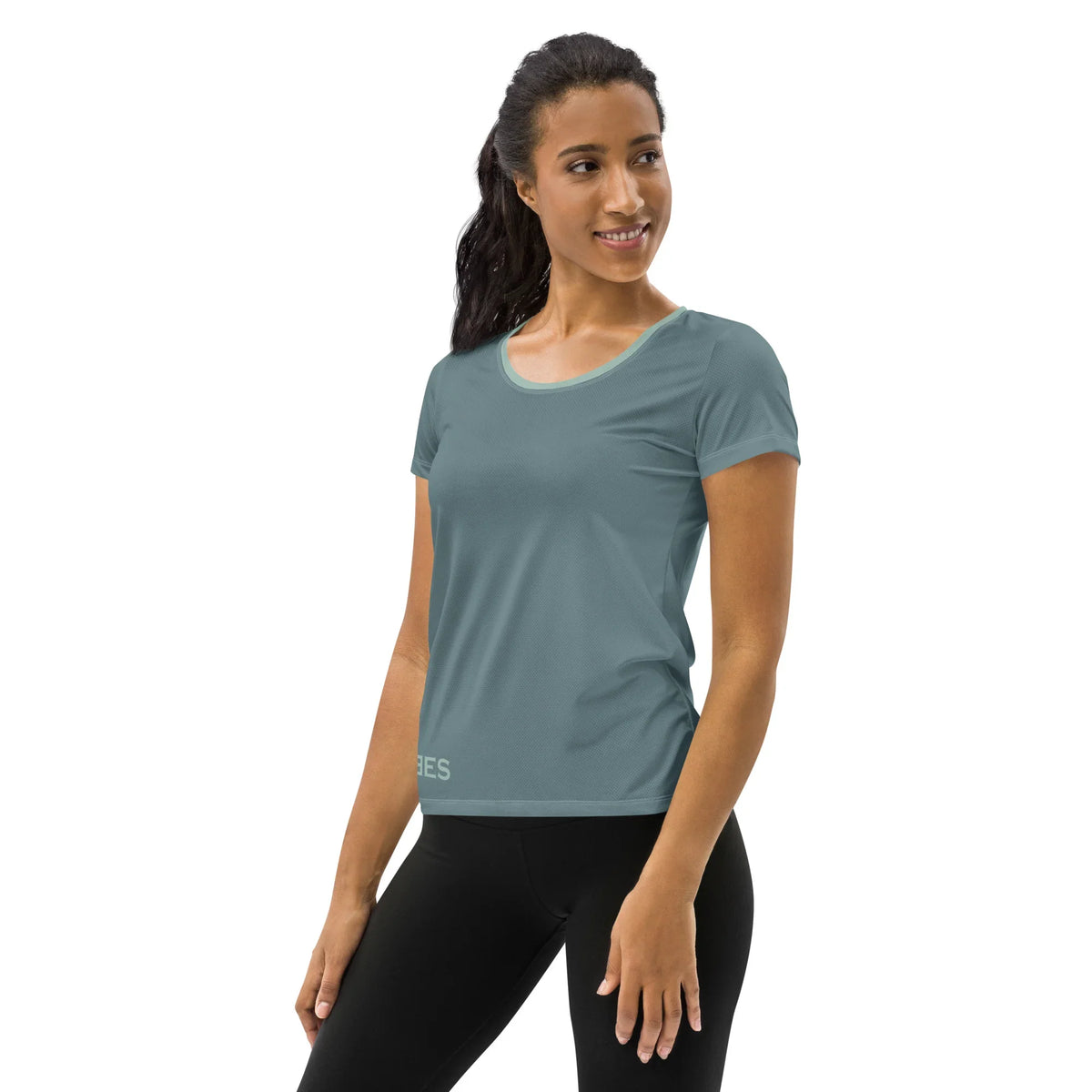 Frau in sportlichem, einfarbigen Damen T-Shirt und Leggings vor weißem Hintergrund