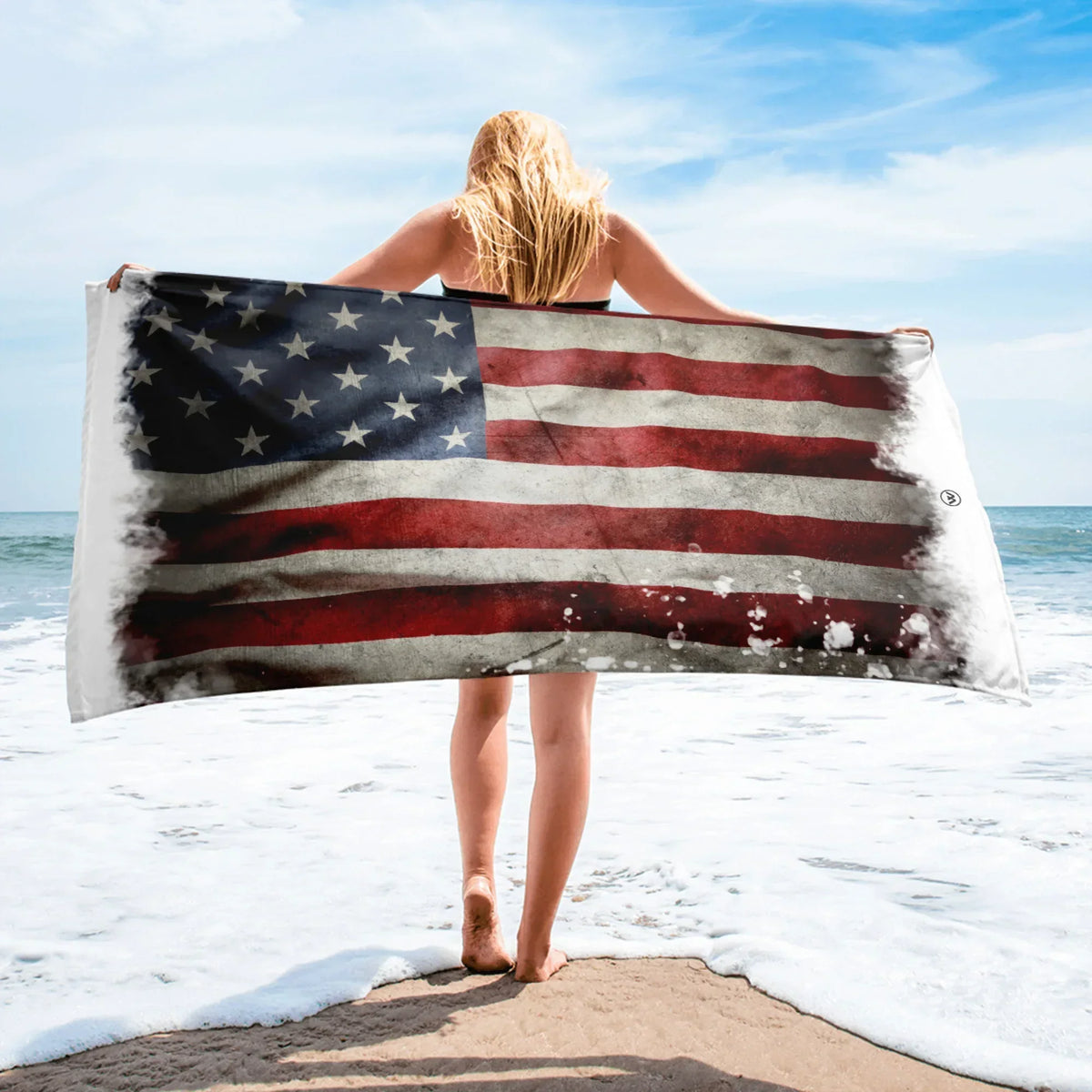 Frau hält CREWILD Strandtuch mit Vintage USA-Flagge am Strand