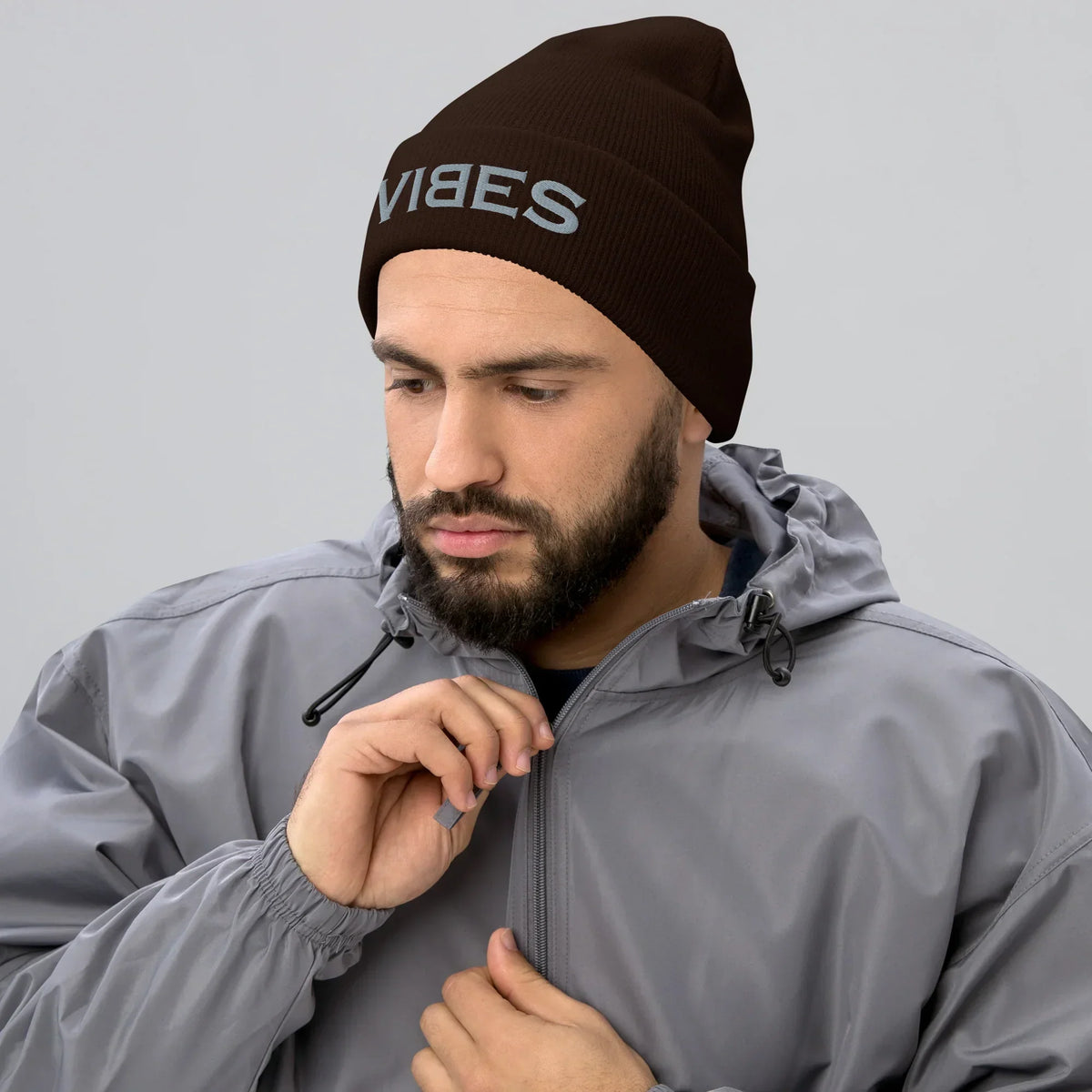 Mann trägt eine braune CREWILD Beanie Mütze mit grauem VIBES Stick