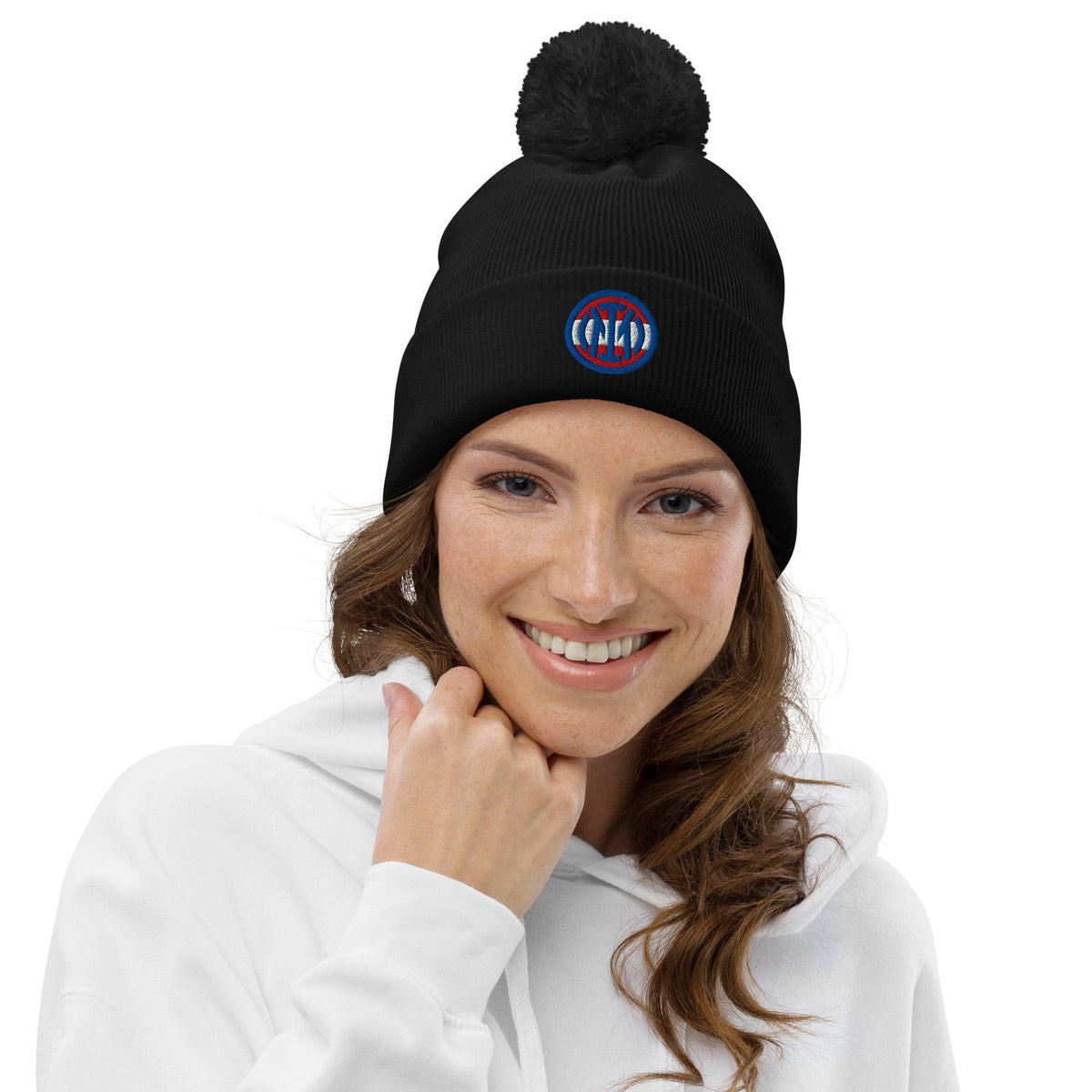 Frau trägt eine schwarze CREWILD Bommel Beanie mit rundem Logo auf weißem Hintergrund