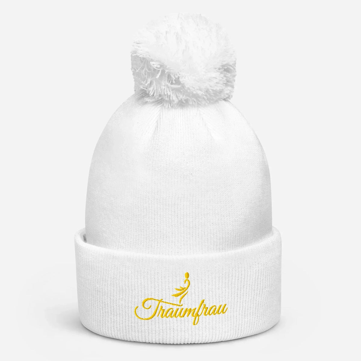 Weiße CREWILD Bommel-Beanie mit gelbem „Traumfrau“-Stick und Symbol auf dem Umschlag.