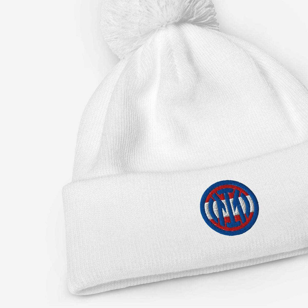 Weißer ICA Bommel Beanie von CREWILD mit rundem gesticktem Logo auf dem Umschlag.