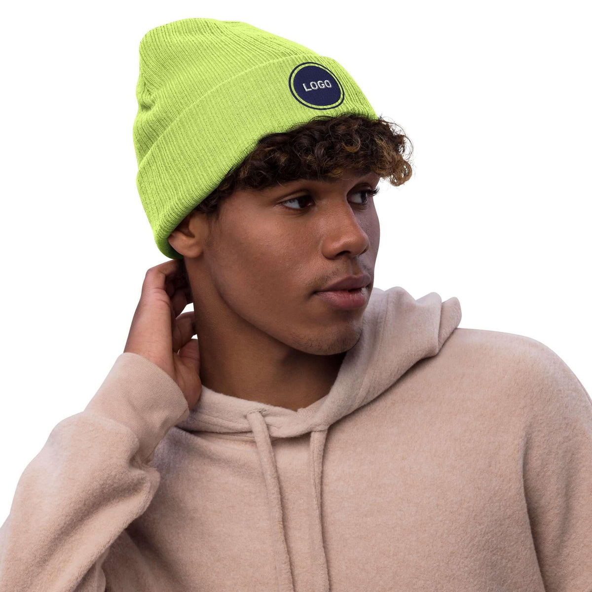 Junger Mann mit neongelber Strickmütze und beigem Hoodie