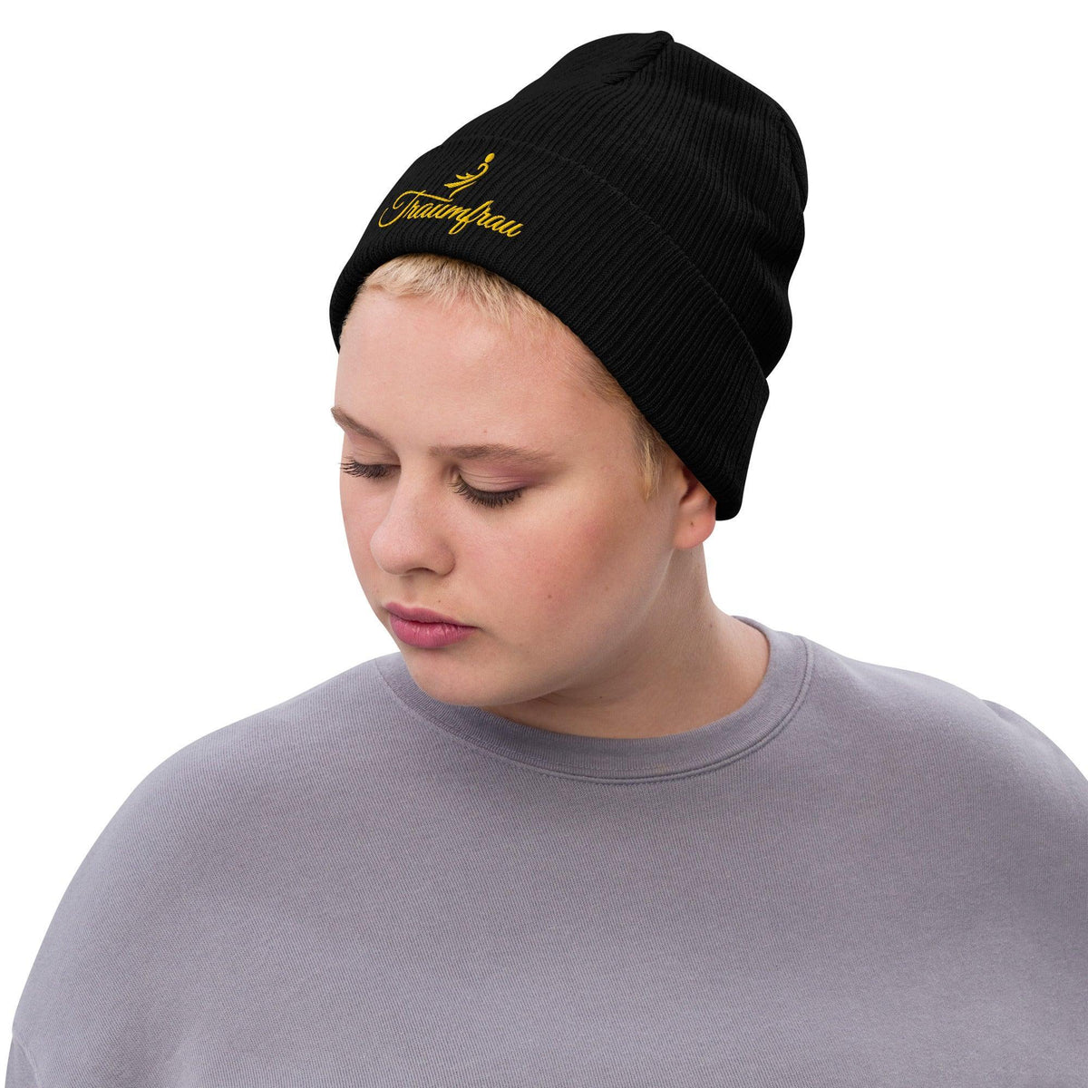 Person trägt eine schwarze CREWILD Beanie Strickmütze mit goldenem "Traumfrau" Schriftzug.