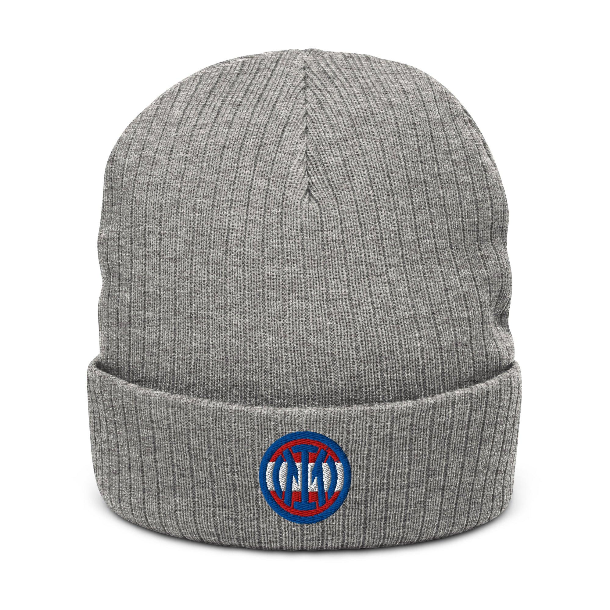 Graue CREWILD Beanie Mütze mit rundem blau-rotem Logo-Stick auf dem Umschlag.