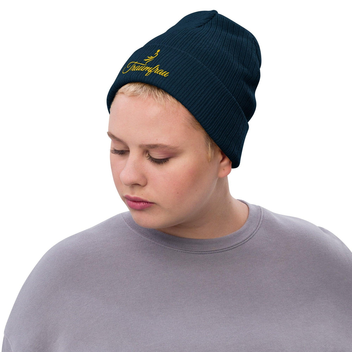Person trägt eine dunkelblaue CREWILD Beanie Strickmütze mit gelbem Traumfrau-Schriftzug.