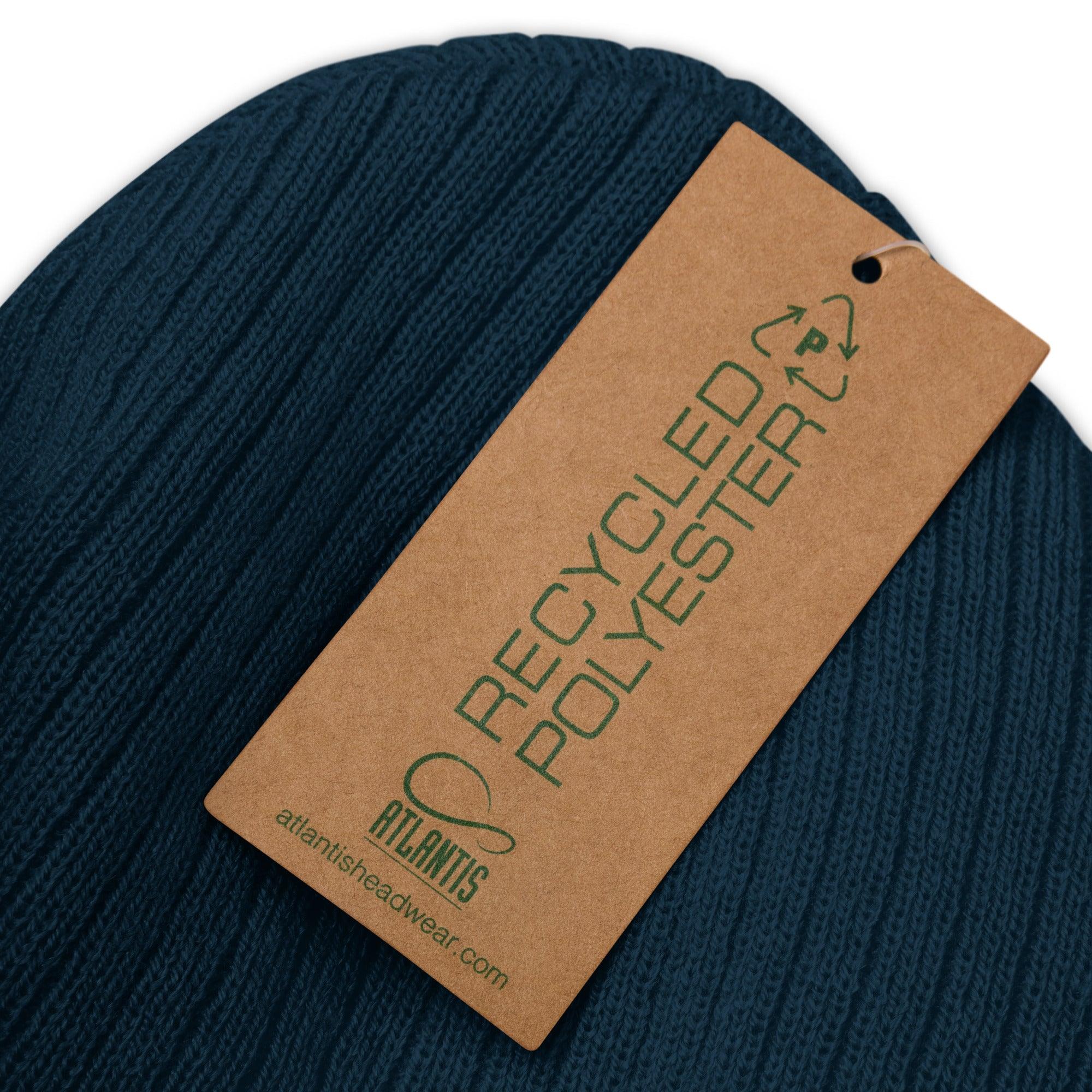 Nahaufnahme einer dunkelblauen CREWILD Beanie aus recyceltem Polyester mit braunem Etikett.