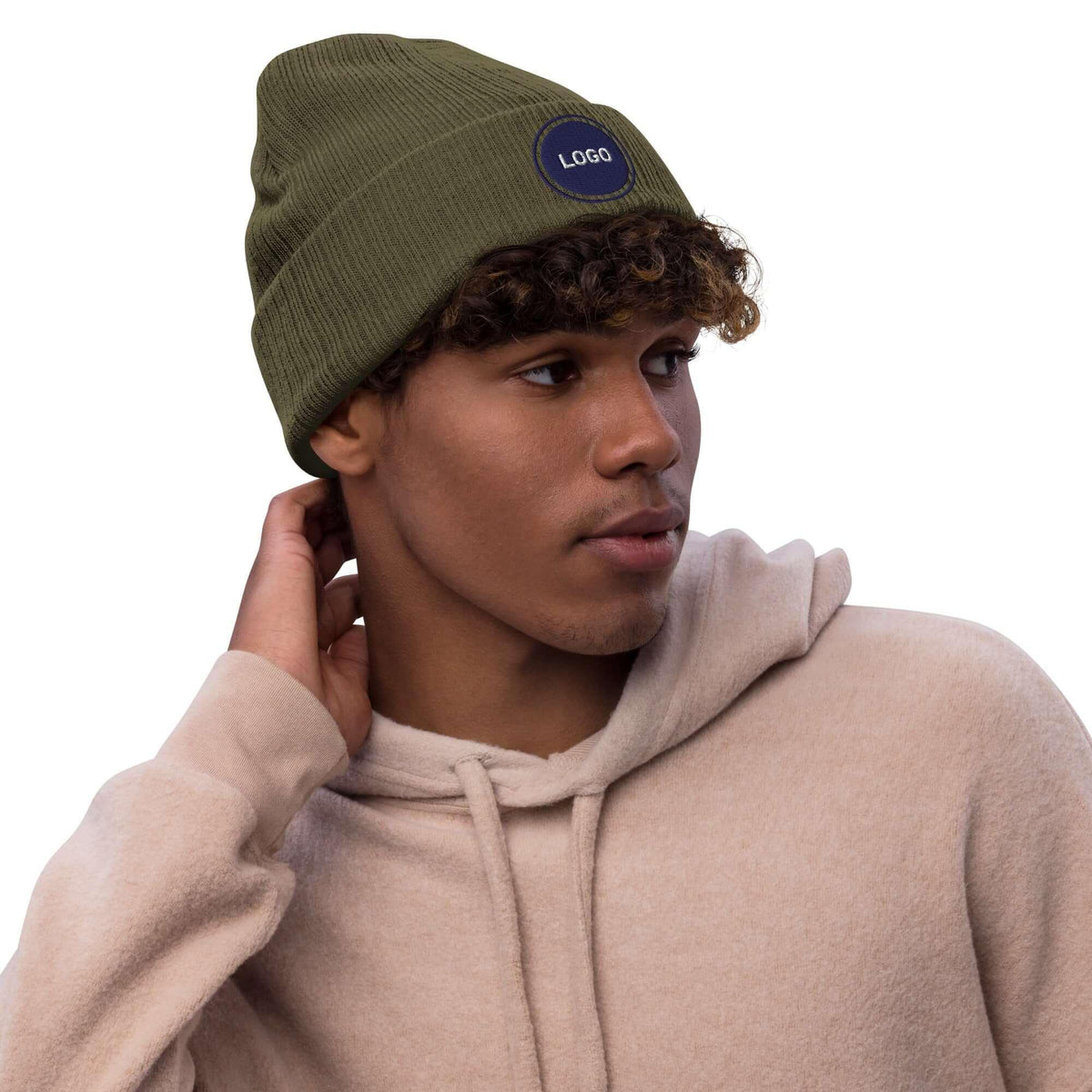 Mann mit olivgrüner Beanie-Mütze und beigem Hoodie vor weißem Hintergrund