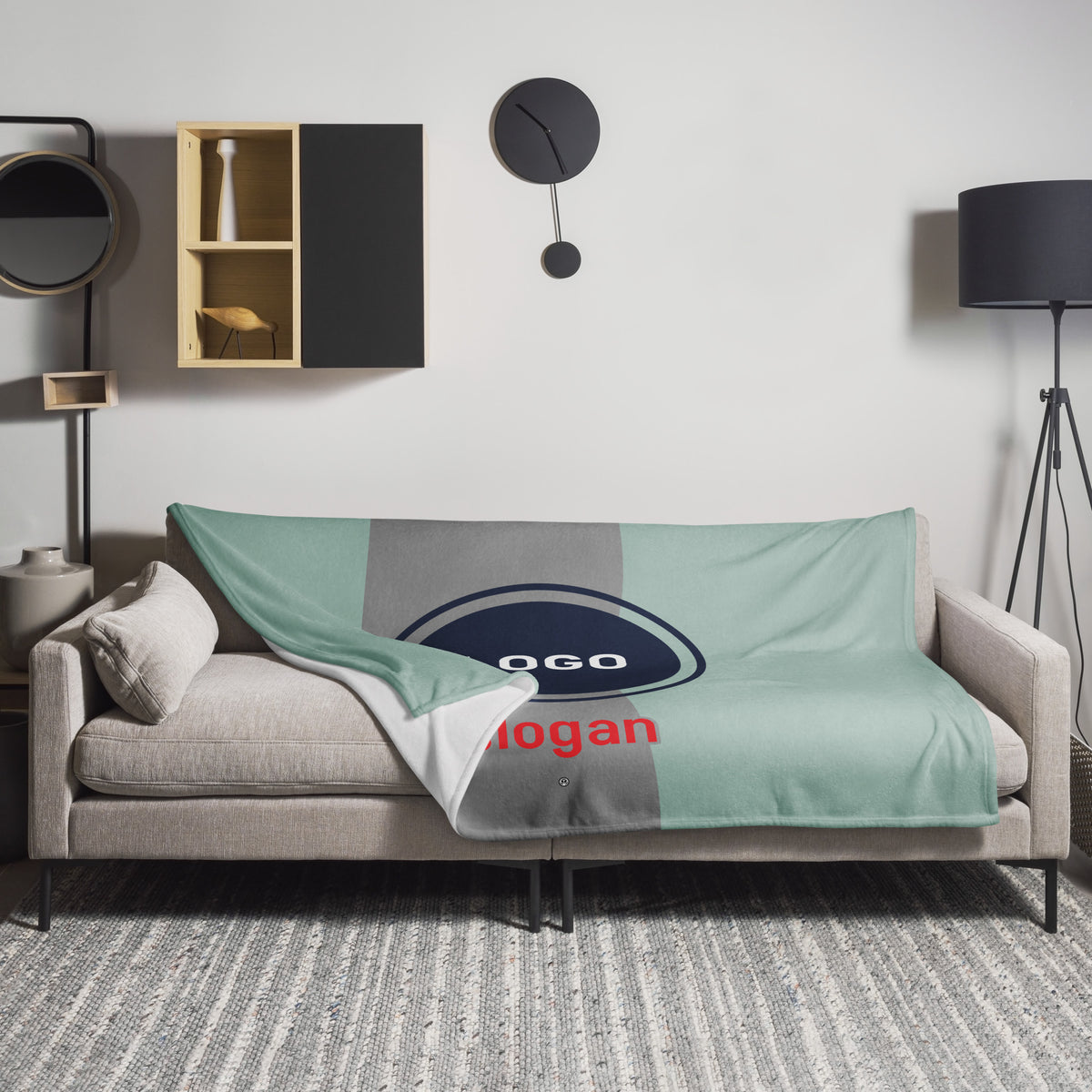 Personalisierbare Tagesdecke von CREWILD mit individuellem Logo auf einem modernen Sofa