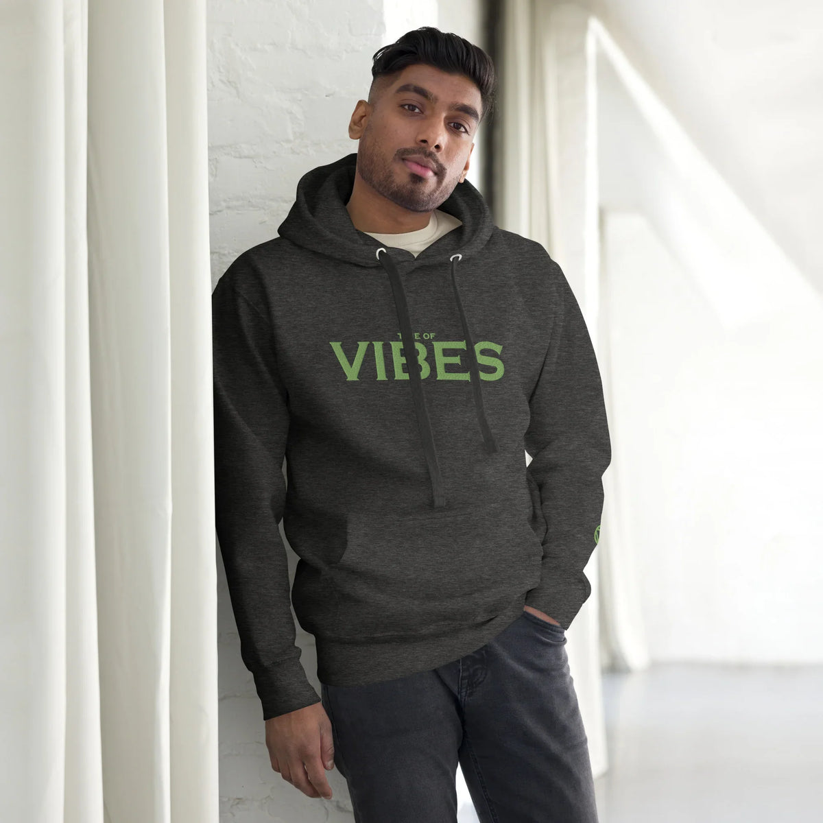 Mann in dunklem Hoodie mit grünem 'TIME OF VIBES' Print, personalisierbarer Streetwear-Look