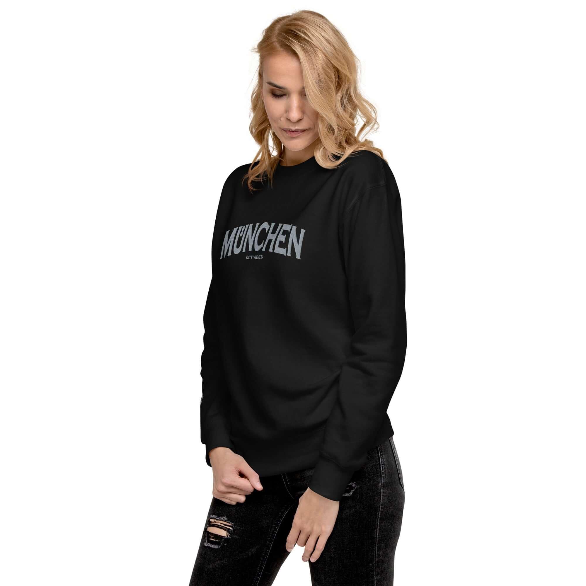 Frau trägt schwarzen Unisex-Premium-Sweatshirt mit München City Vibes Print, Modefoto