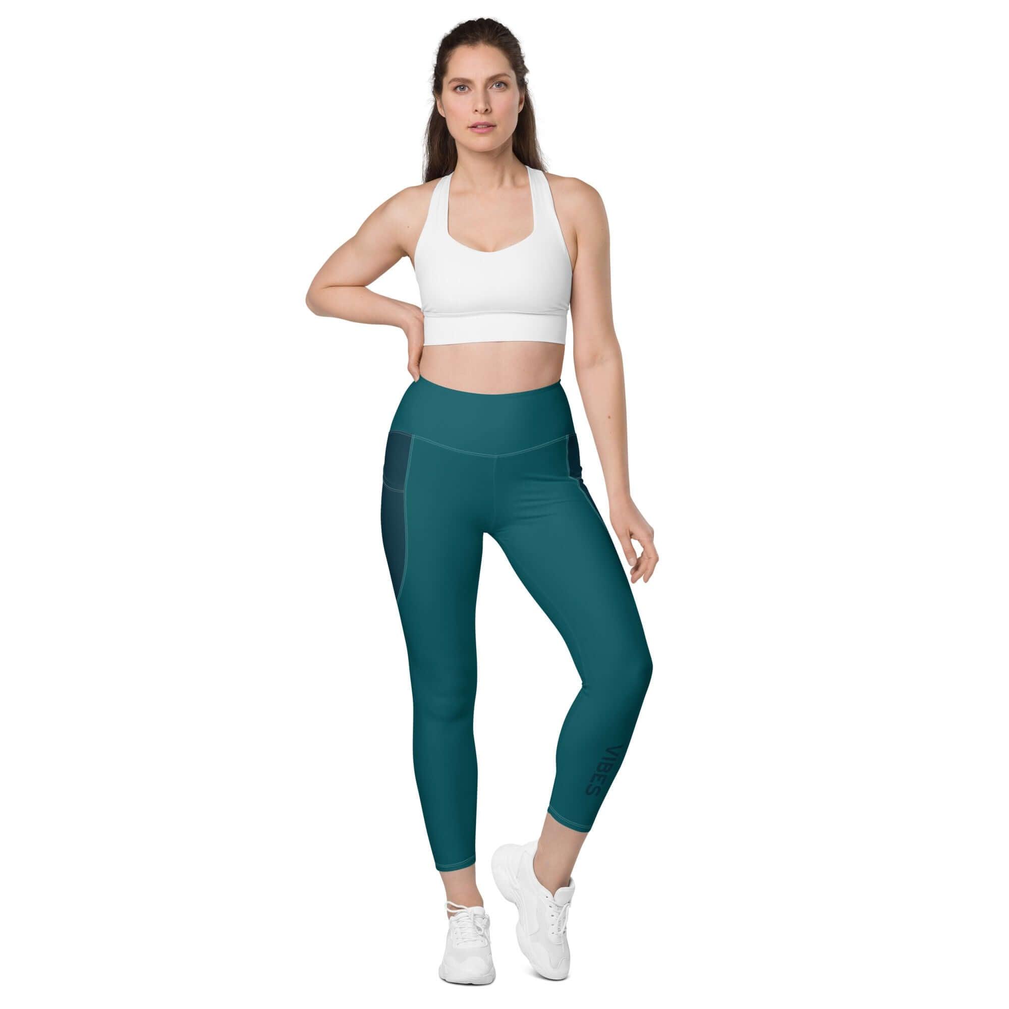 Frau trägt blaue Leggings mit Taschen und weißem Sport-BH auf weißem Hintergrund