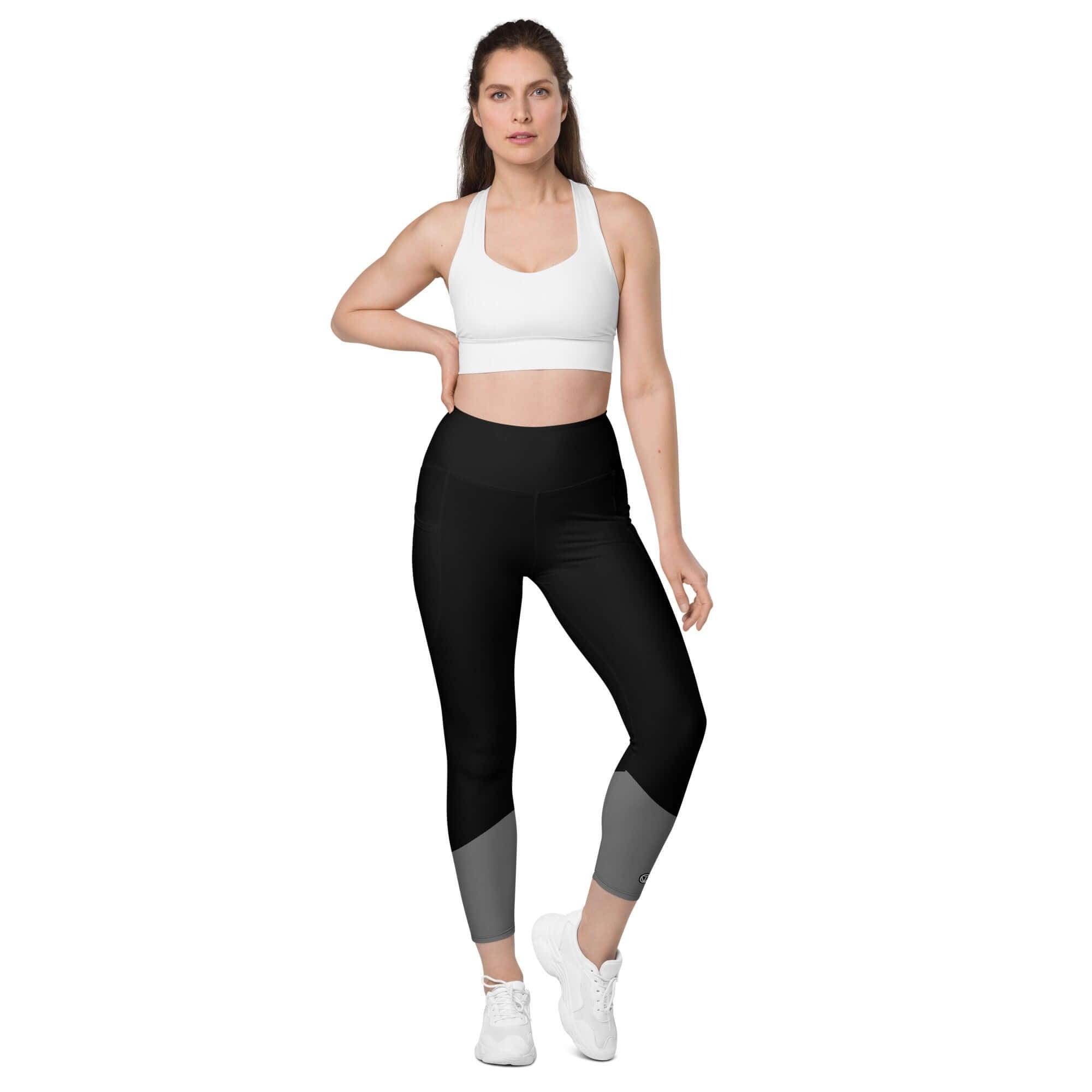 Frau trägt schwarze Leggings mit Taschen, weißem Sport-BH und weißen Turnschuhen vor weißem Hintergrund