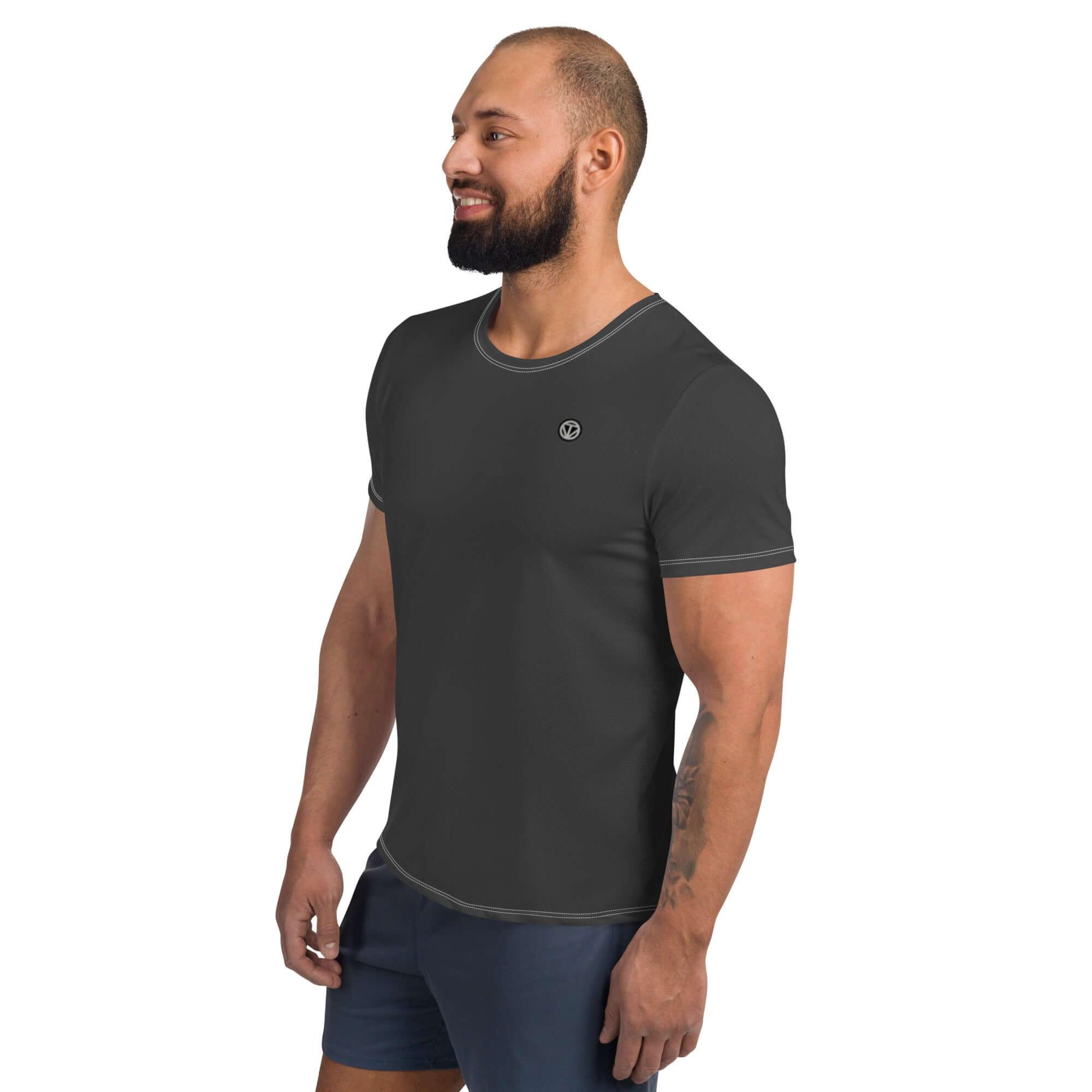 Mann mit schwarzem Sport-T-Shirt und kurzem Schnitt, lächelt vor weißem Hintergrund