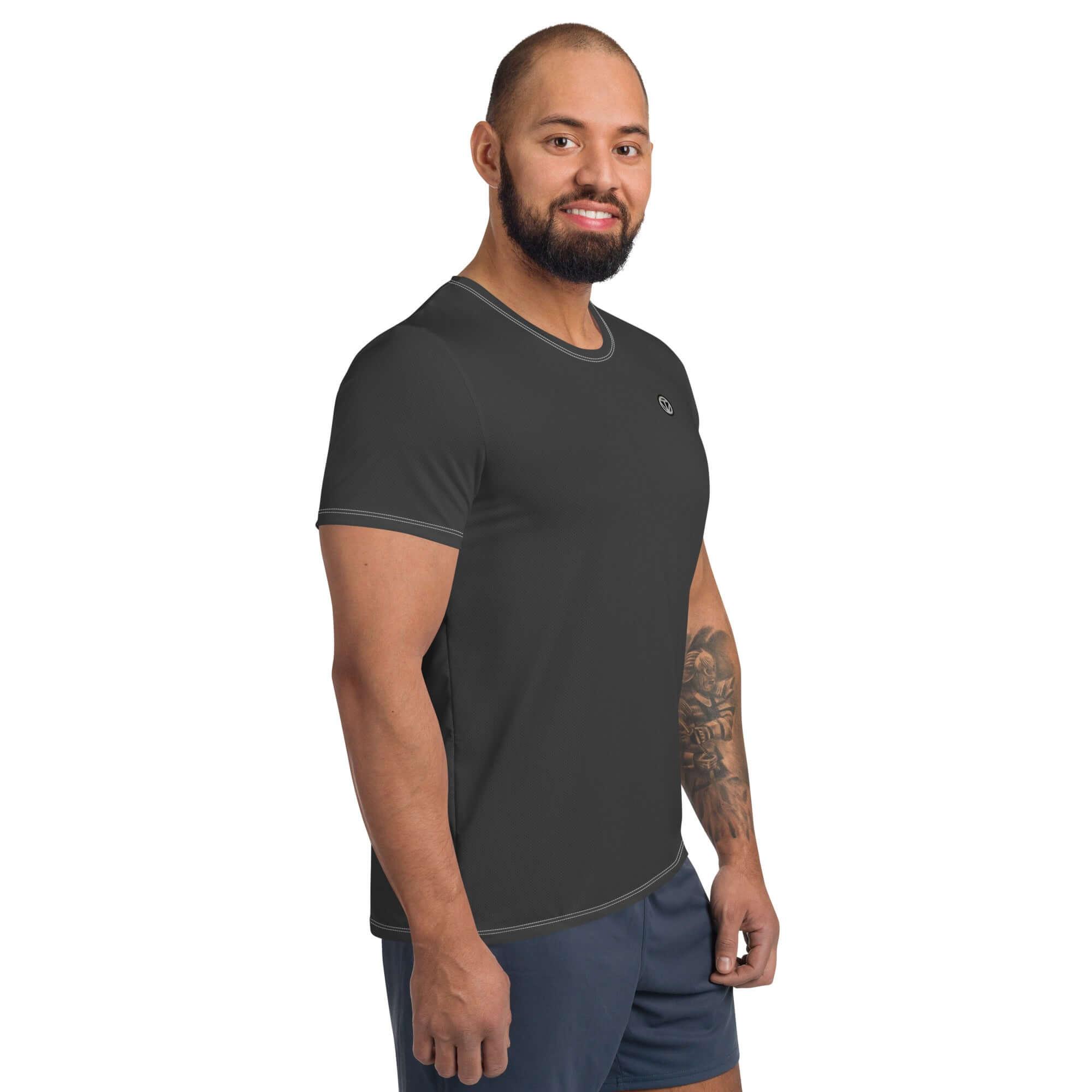 Mann im schwarzen Sportshirt und kurzen Hosen vor weißem Hintergrund, Fitnessmode