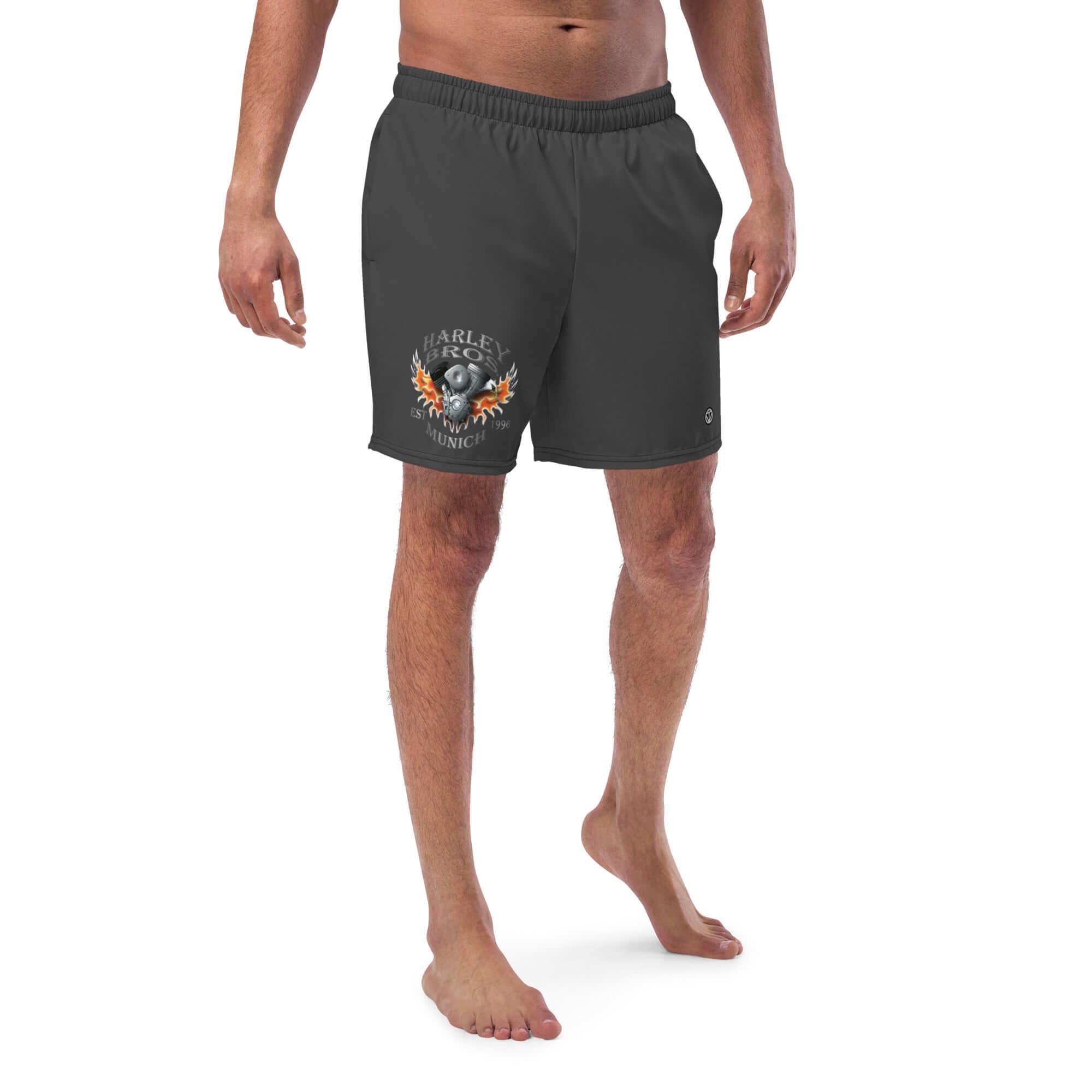 Mann trägt schwarze Badeshorts mit Harley Bros München Flammen-Logo, seitliche Ansicht